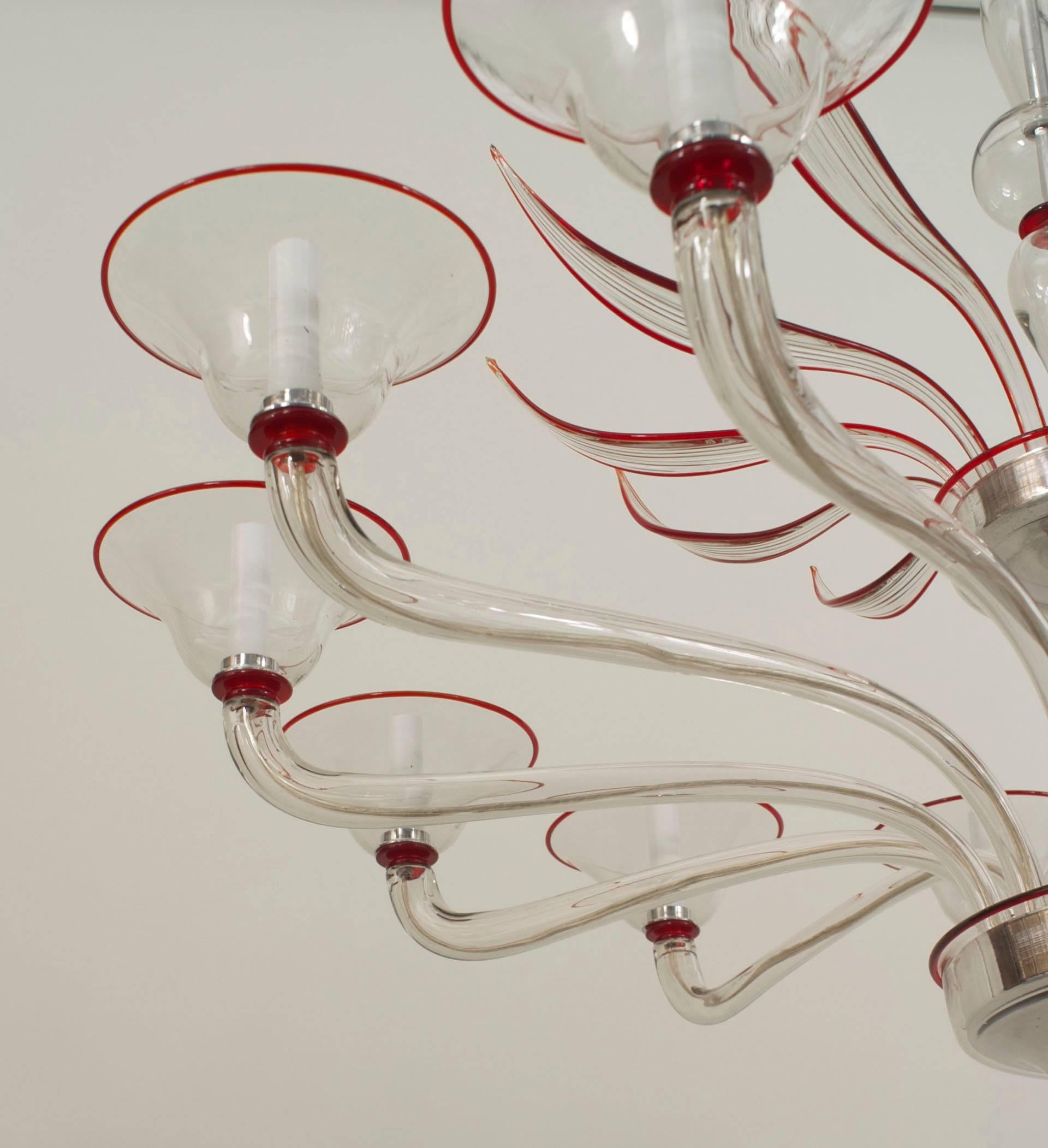 Italian Venetian-Style Murano (1940s) clear glass and red trimmed chandelier with 12 scroll arms under a tier of 12 feathers emanating from a center shaft with a final bottom.

