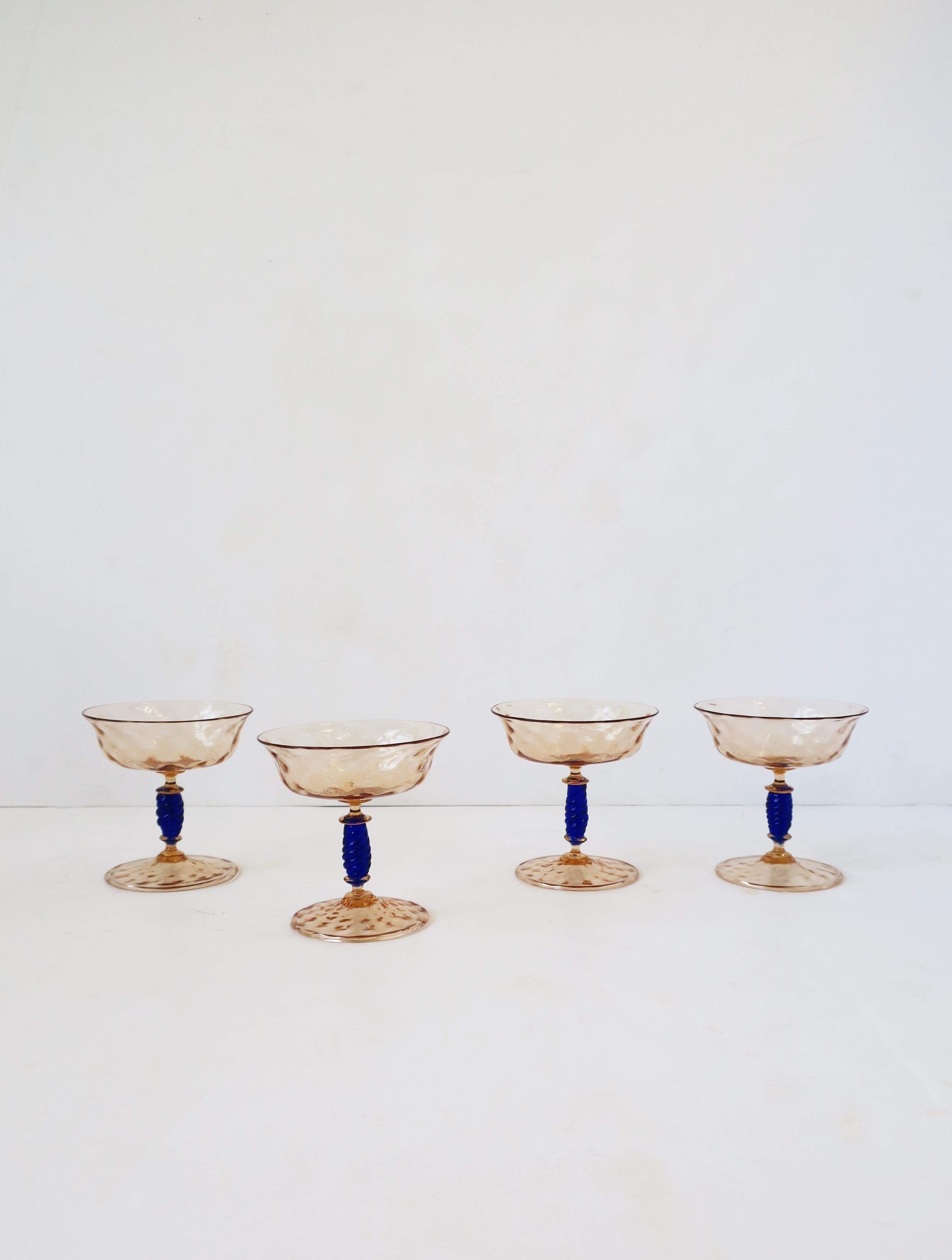 A beautiful set of four (4) Italian Venetian Murano art glass Champagne coups glasses. Glasses are a beautiful combination of rose-gold and sapphire blue hue Murano art glass. Great for Champagne or a cocktail; For summer or holiday entertaining,