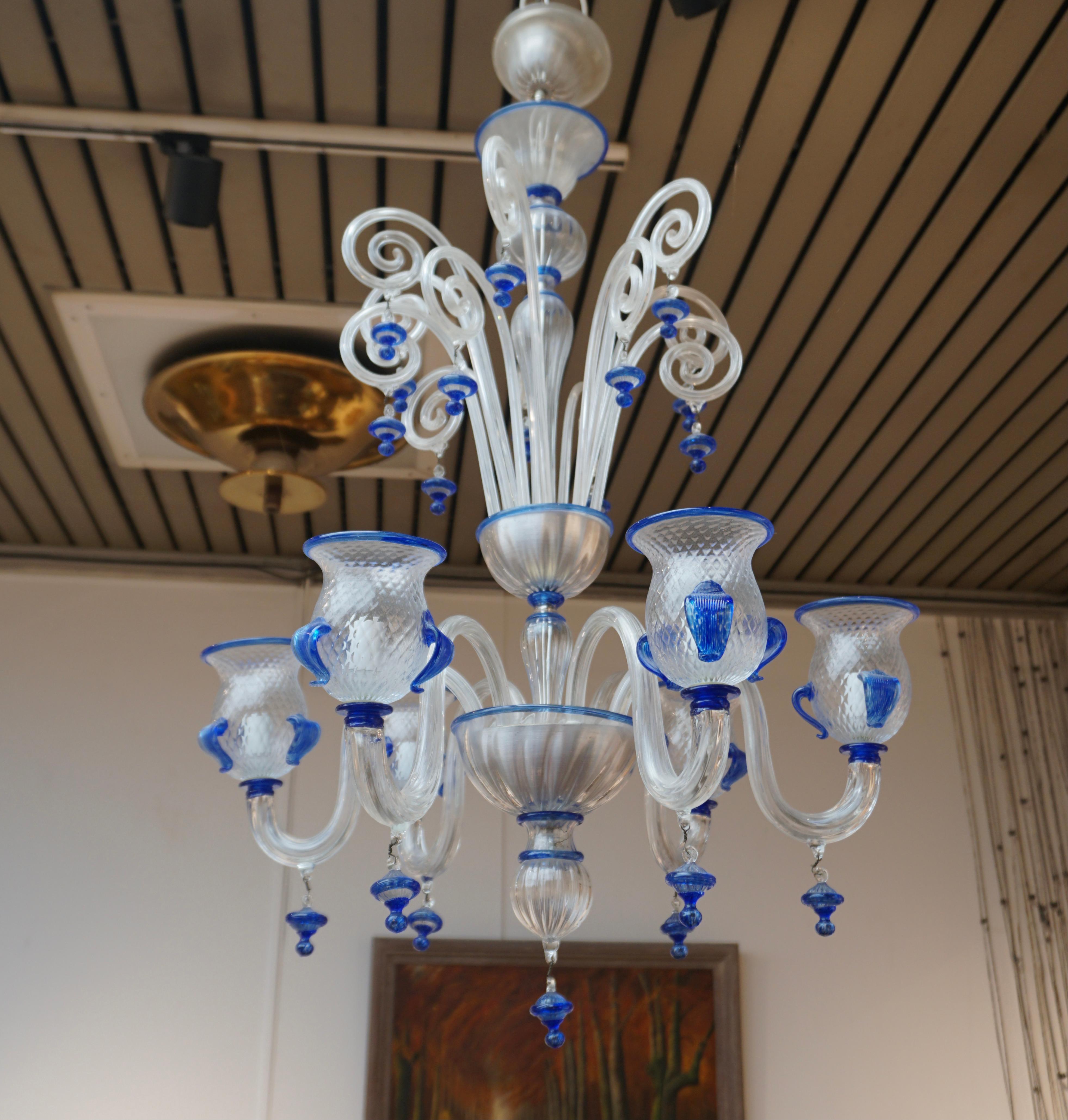 Italian Venetian Murano (1970s) blue and transparent glass chandelier with 6 arms.

The light requires six single E14 screw fit lightbulbs (60Watt max.) LED compatible.

Measures: Diameter 27.5 inch - 70 cm.
Height fixture 37.4 inch - 95