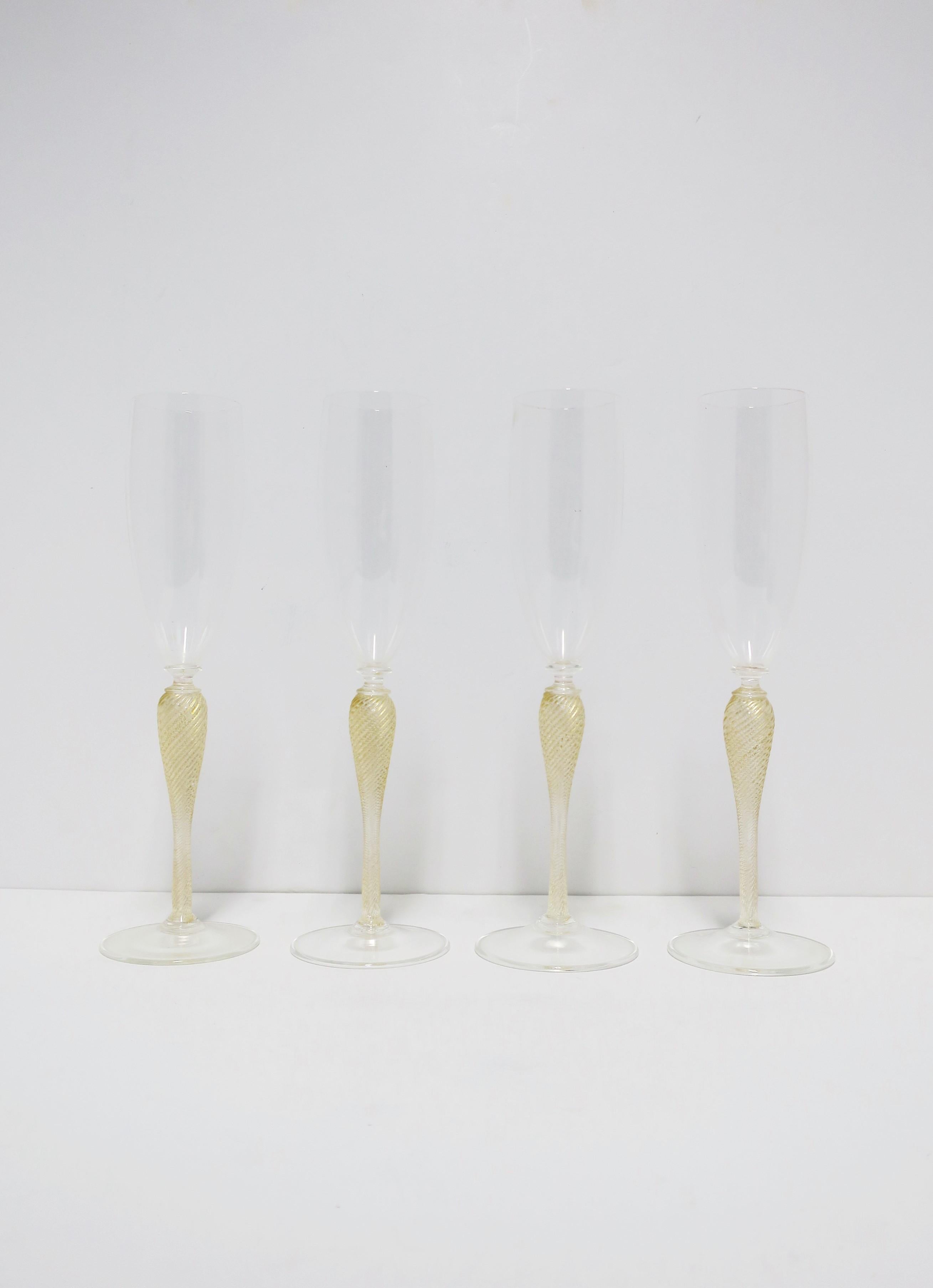 A beautiful set of four (4) Italian Venetian Murano gold and transparent art Champagne or cocktail flute glasses by Cenedese, circa late-20th century, Italy. Enjoy Champagne, Champagne cocktail, other cocktails, etc., with this beautiful set of