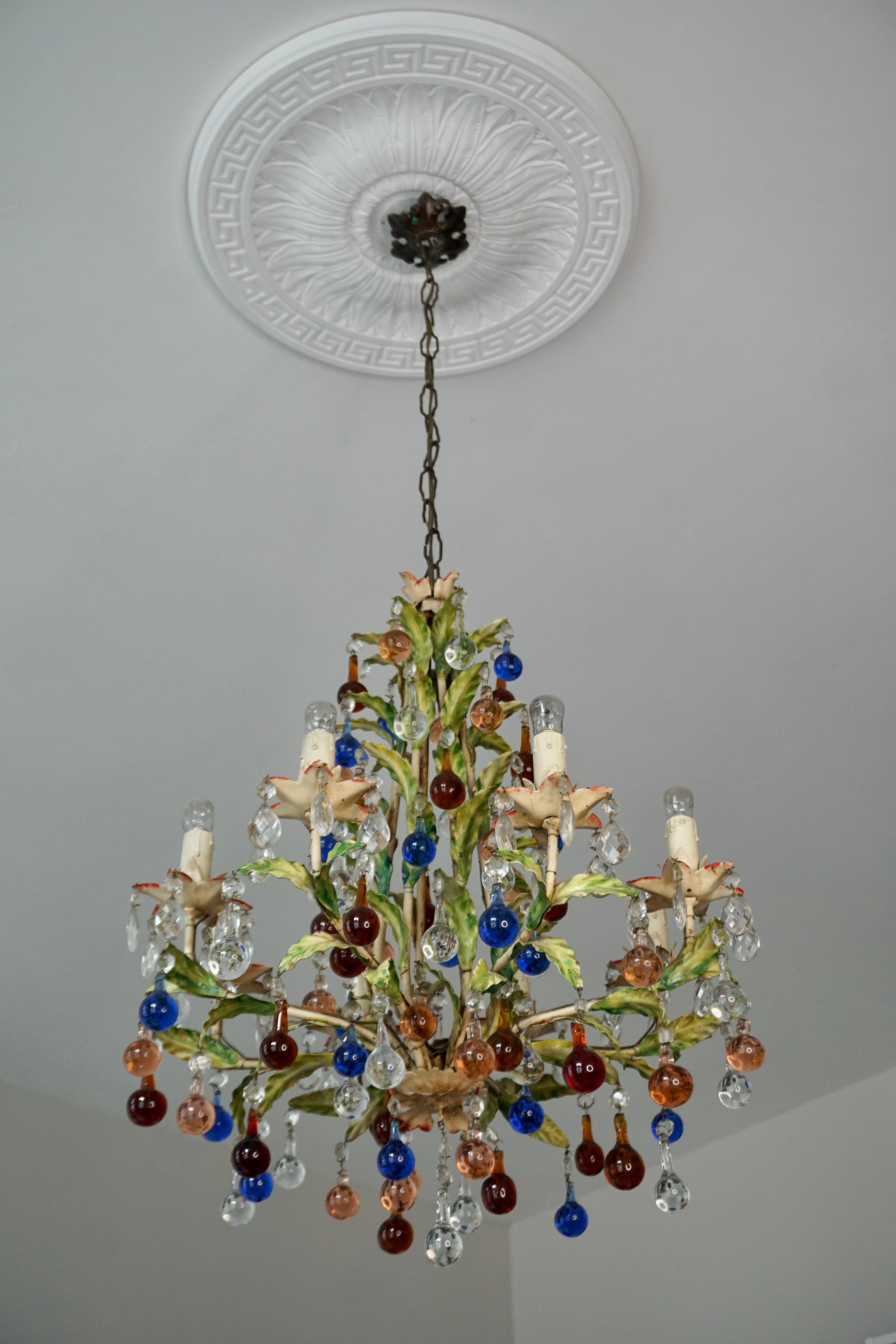 Stunning chandelier with multicolored Murano glass.Manufactured in the 1950-1960s in Italy.

Italian Venetian gilt metal 8-light chandelier with Murano glass from the mid 20th Century. This impressive and beautiful Italian Hollywood Regency-style