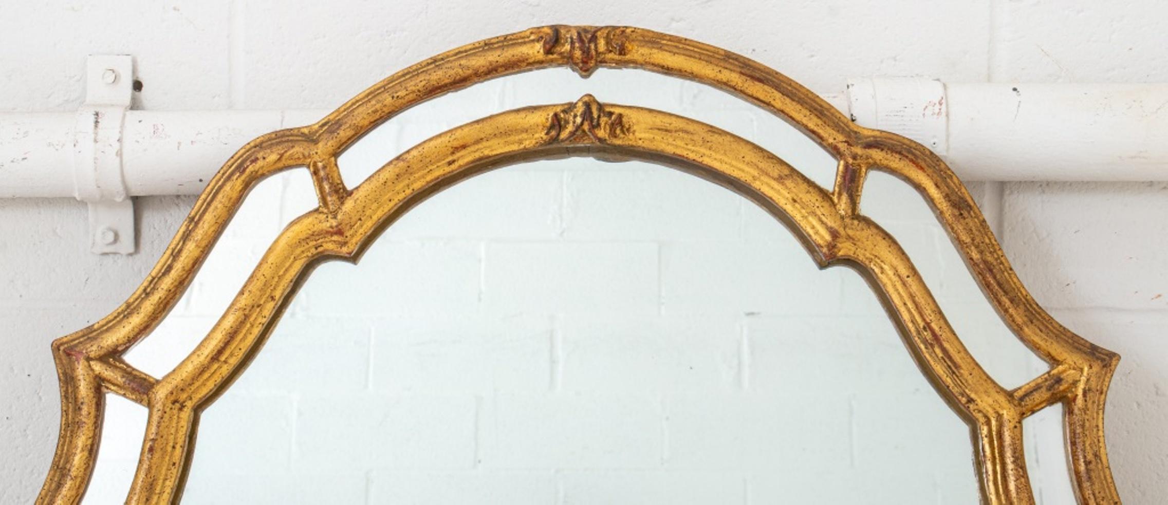 Italian Venetian style giltwood mirror, with shaped top and sides with eight inset mirrored panels surrounding a rectangular mirror plate, the reverse with paper label reading 