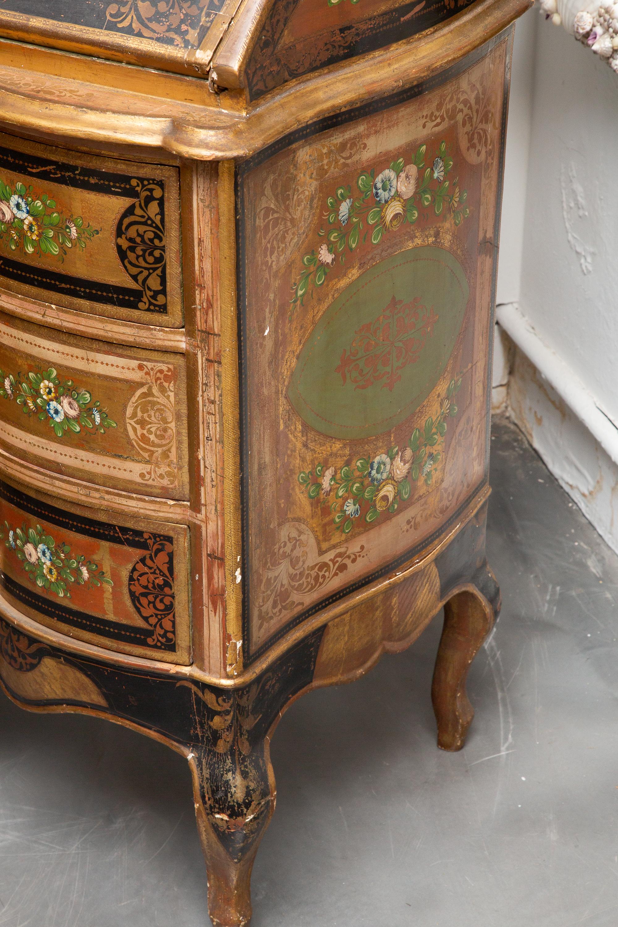 This is a classic Venetian style polychrome lacquered bookcase. This case piece is exquisitely hand painted with floral decoration and overall parcel gilt.