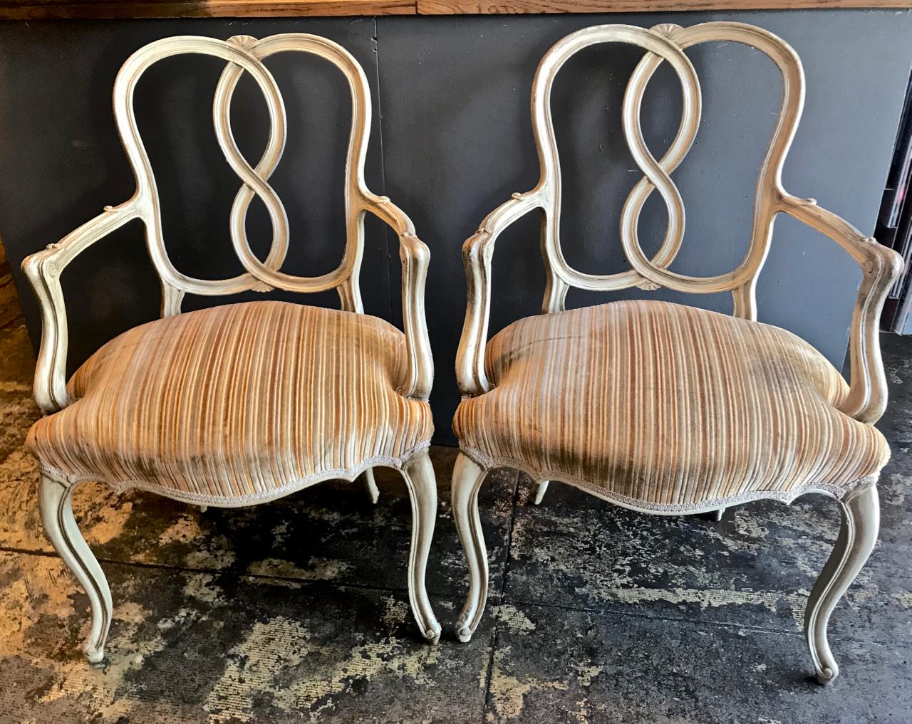 This is a great set of circa 1960s-1970s carved Venetian style ribbon-back painted dining chairs. The beautifully carved arms of the host chairs is a sign of quality craftsmanship. The chairs retain their original painted finish and vintage striped