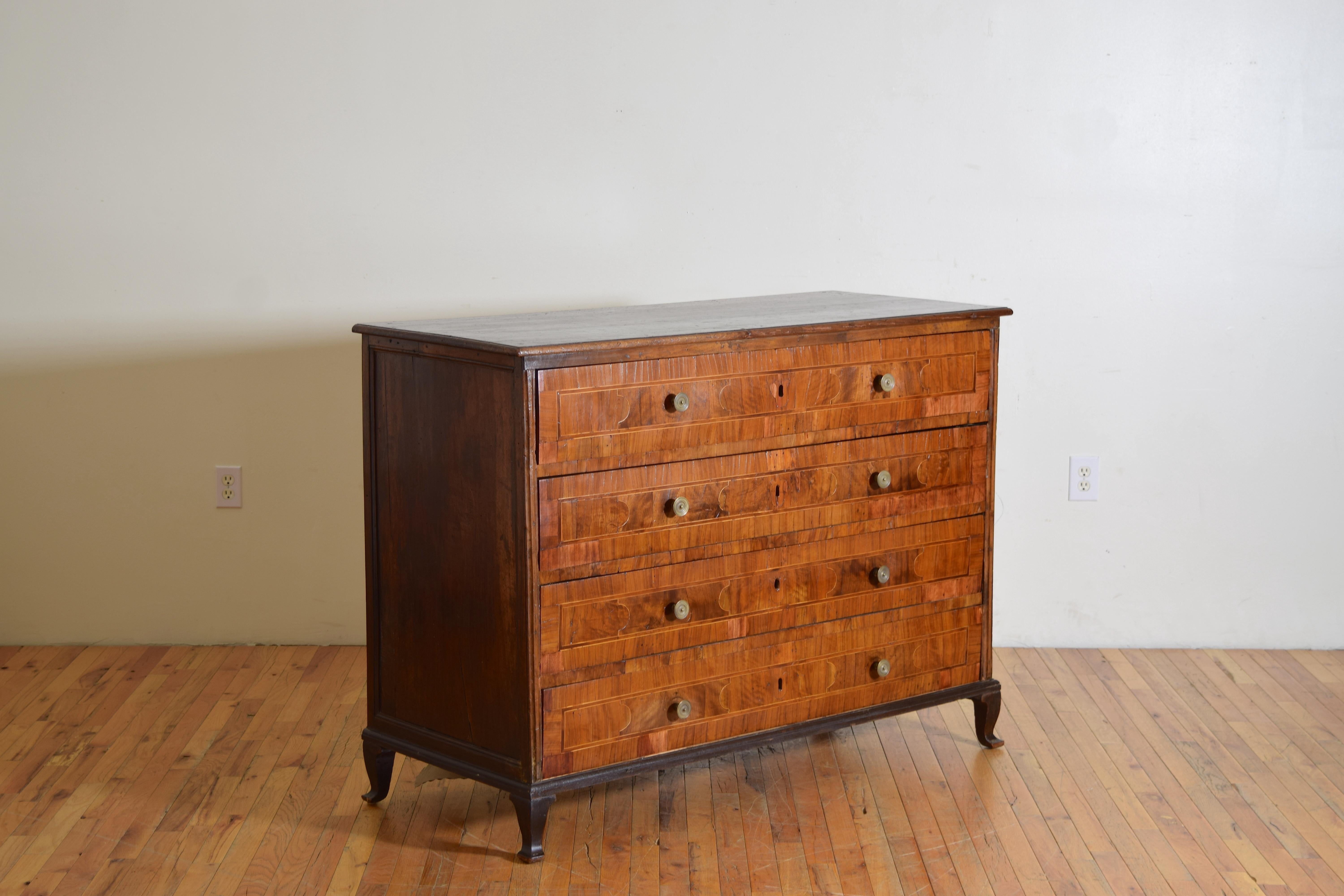 having a solid walnut rectangular top and sides, the top with a molded edge, the case housing 4 veneered drawers with antique bronze pulls, the small plinth-form base and curved feet are ebonized 
