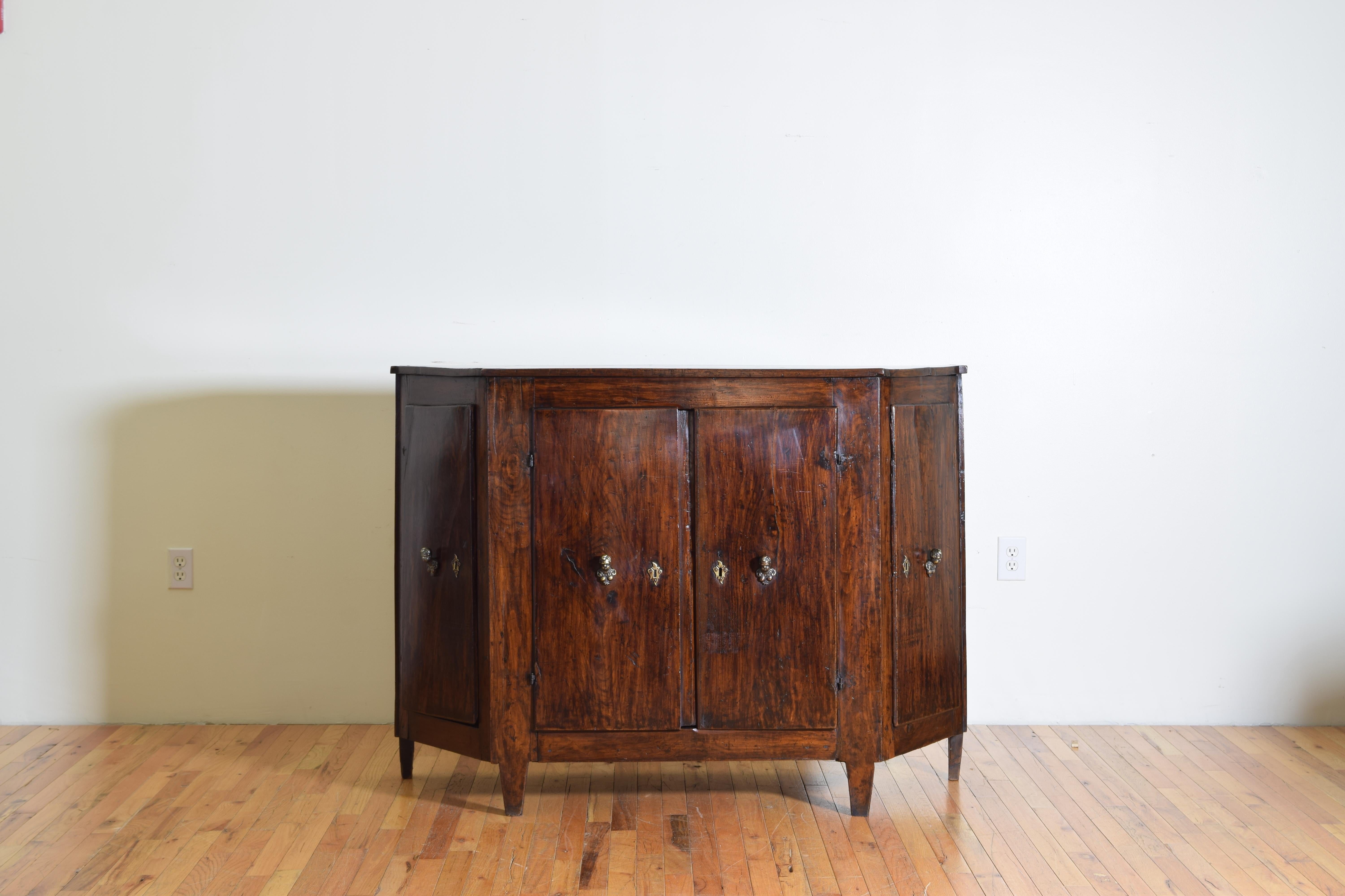 Having a shaped scantonata top with interesting front notches above a conforming case housing two side drawers, 4 doors, and antique shelving, bronze putti figural hardware, raised on rectangular tapering legs.