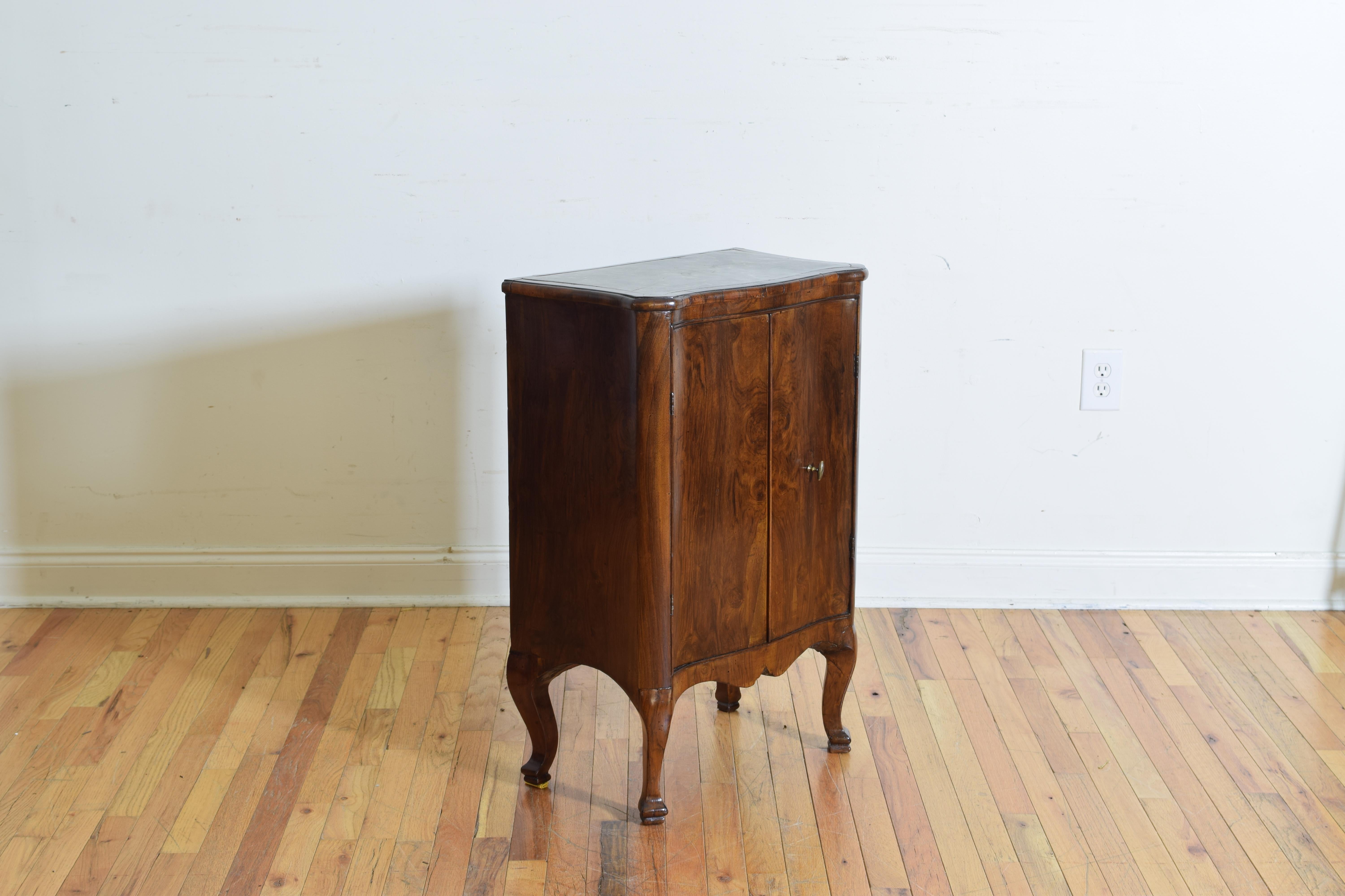 Having a shaped top with an inset marble, the corners rounded and exaggerated, above a conforming case with two doors and an interior with shelving, raised on uniquely carved pad feet, great overall movement in this little cabinet, perfect condition.