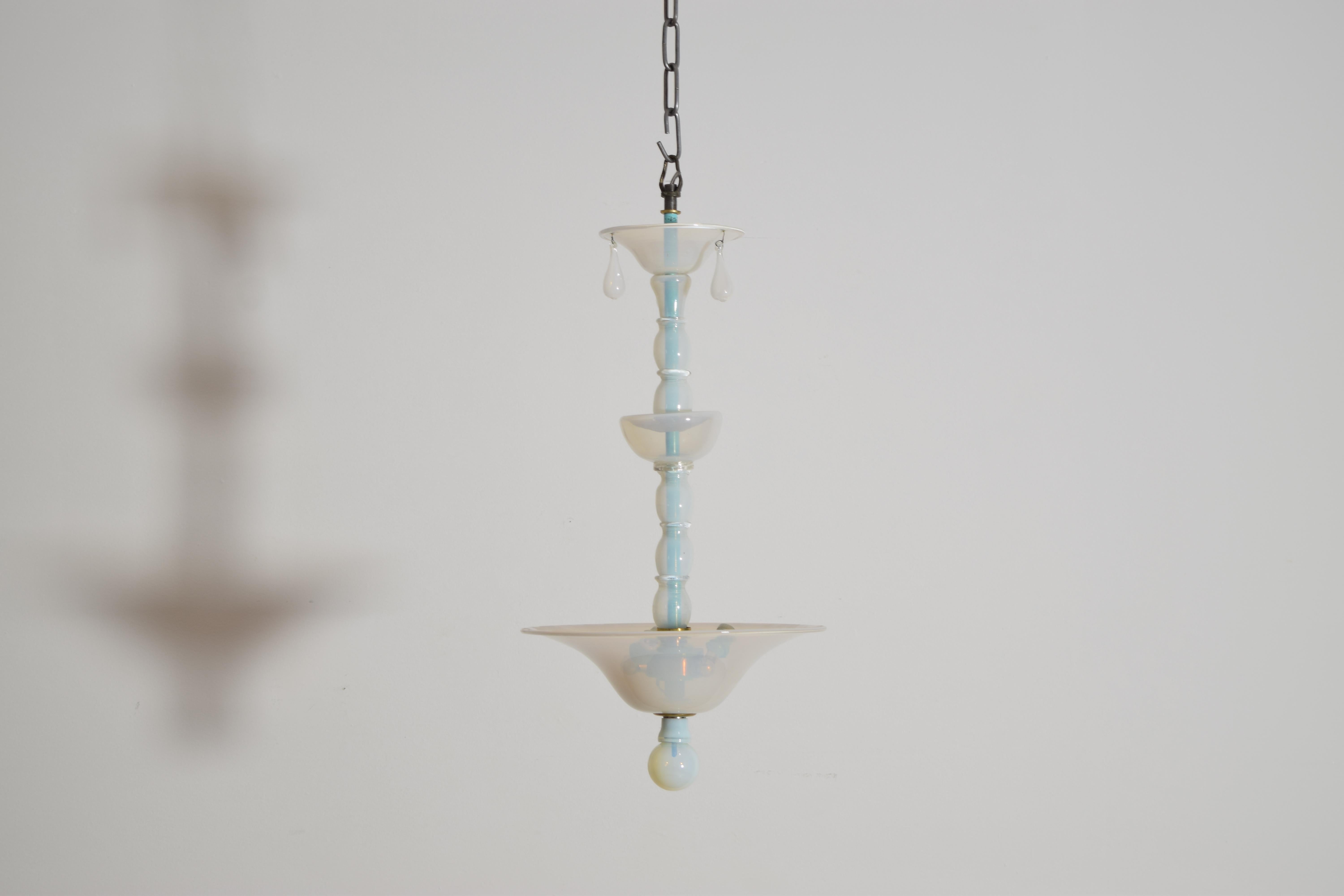 El tallo central sostiene gradas graduadas en forma de cupé sobre un cuenco de vidrio conformado creado con la delicada opalina en tono azul claro/verde.