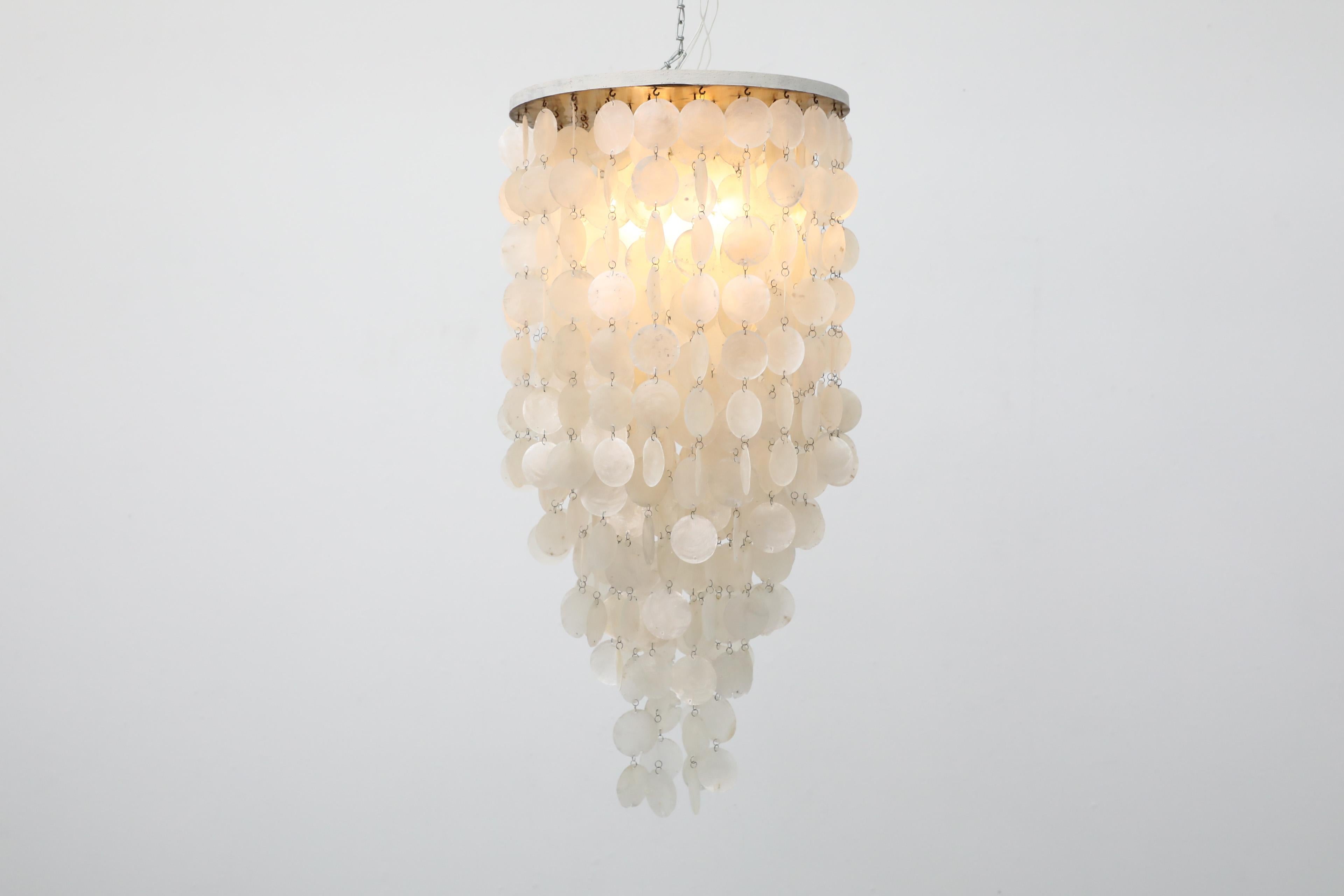 Una cascata di dischi di capiz delicati e multistrato da 2,5 pollici rende questo lampadario italiano ispirato a Verner Panton con baldacchino in metallo tanto impressionante quanto accattivante. Questo pezzo è in condizioni originali con qualche
