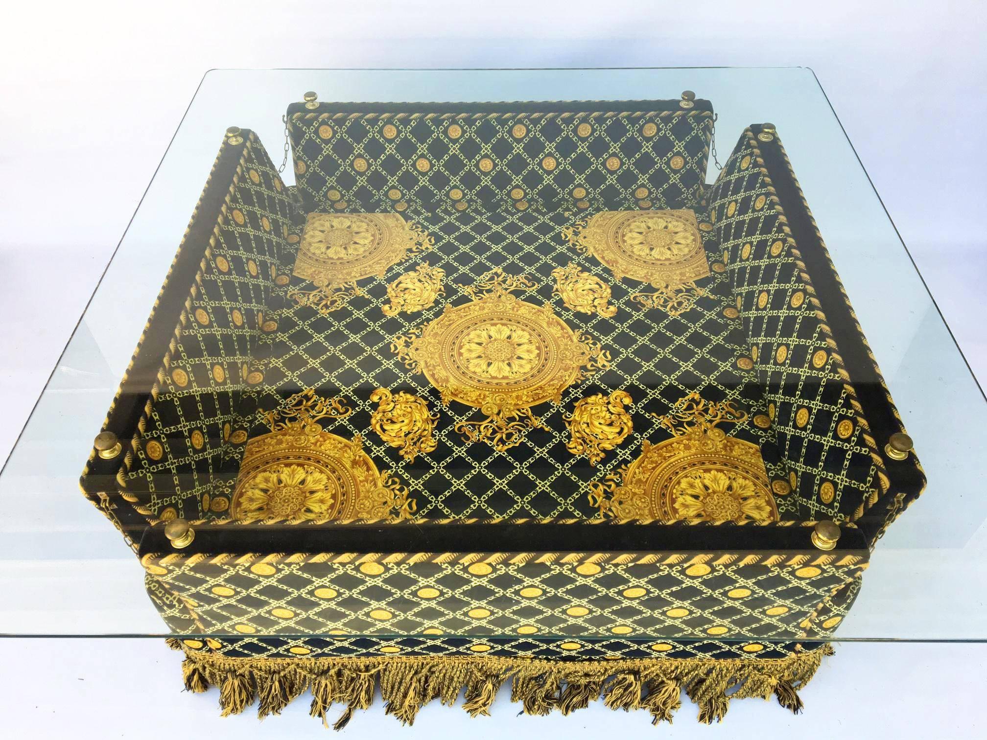 Versace style plush fabric adorns this unique glass-topped coffee table. Features construction reminiscent of Knole style settees with it's flared side arms and brass finials. Marked Stefano Giovanni (Jiovanni) and made in Italy. Excellent vintage