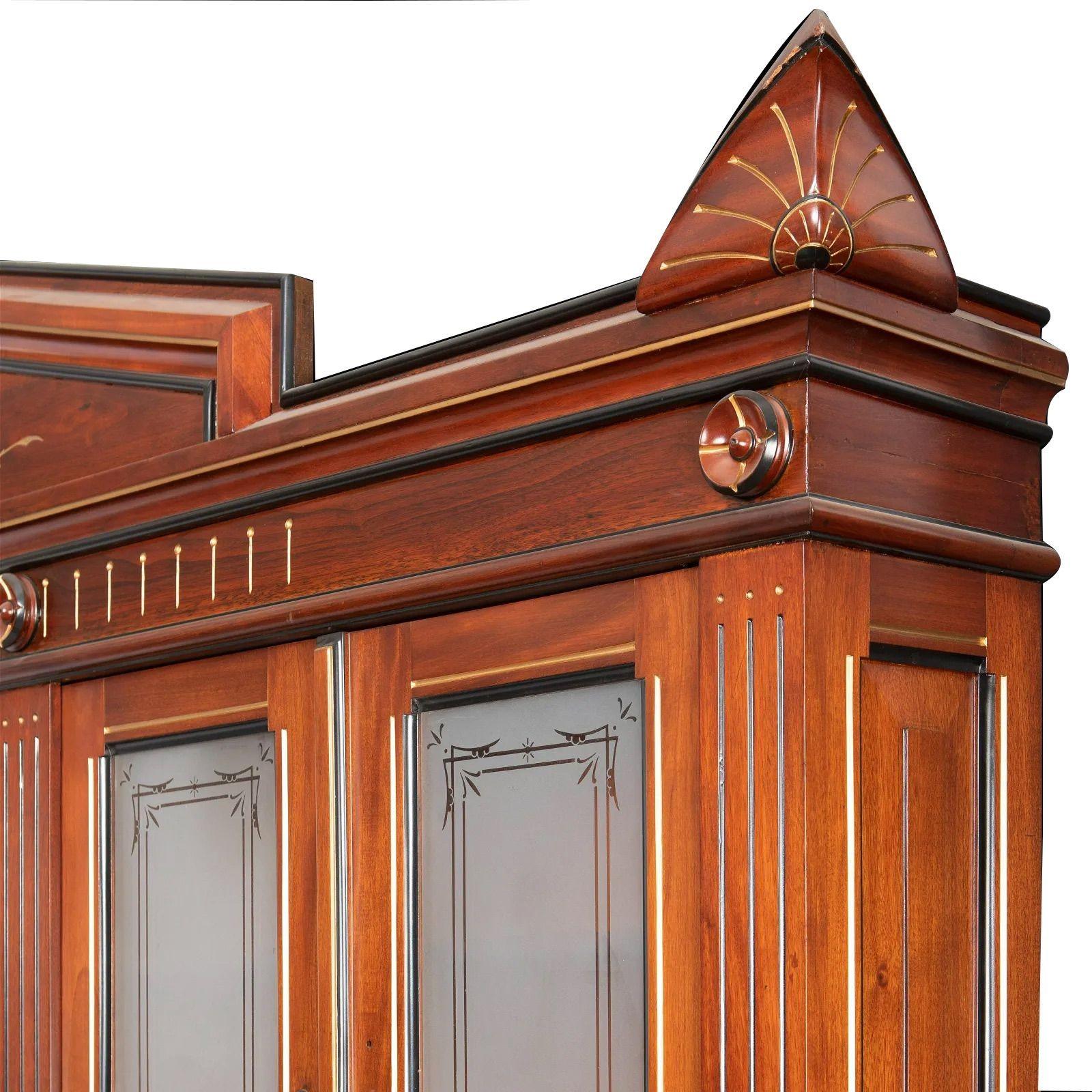 Victorian butler's cabinet, Late 19th century

Italian Renaissance-style, in carved walnut with gilt, ebonized, and glazed highlights with central sphere crest atop six opposing glazed cabinet doors over an open gallery with mirrored back splash