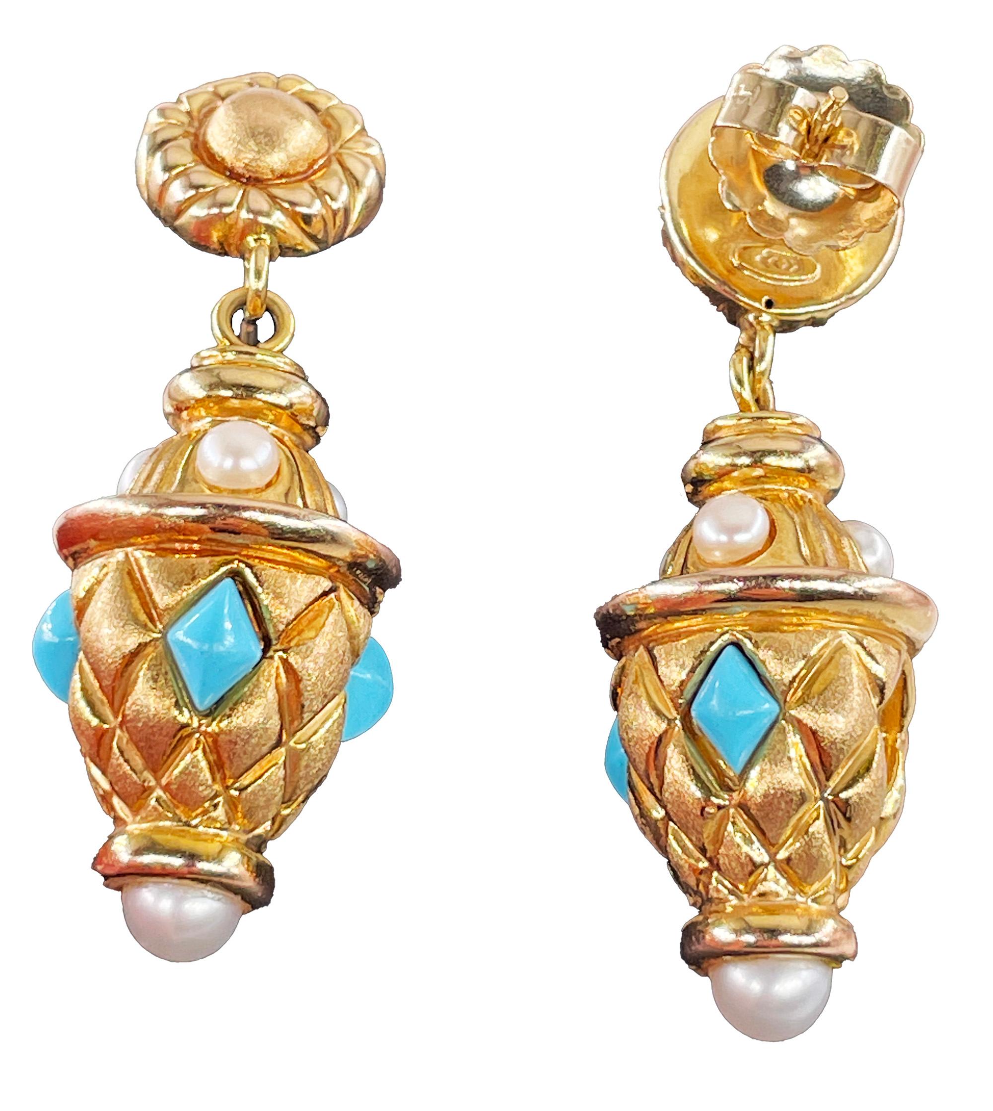 Orecchini pendenti d'epoca in oro giallo 14K di ispirazione esotica etrusca con accenti di perle turchesi.
Scopri il fascino di questi orecchini in oro 14K di manifattura italiana, uno straordinario connubio tra design vintage e comodità d'uso, che
