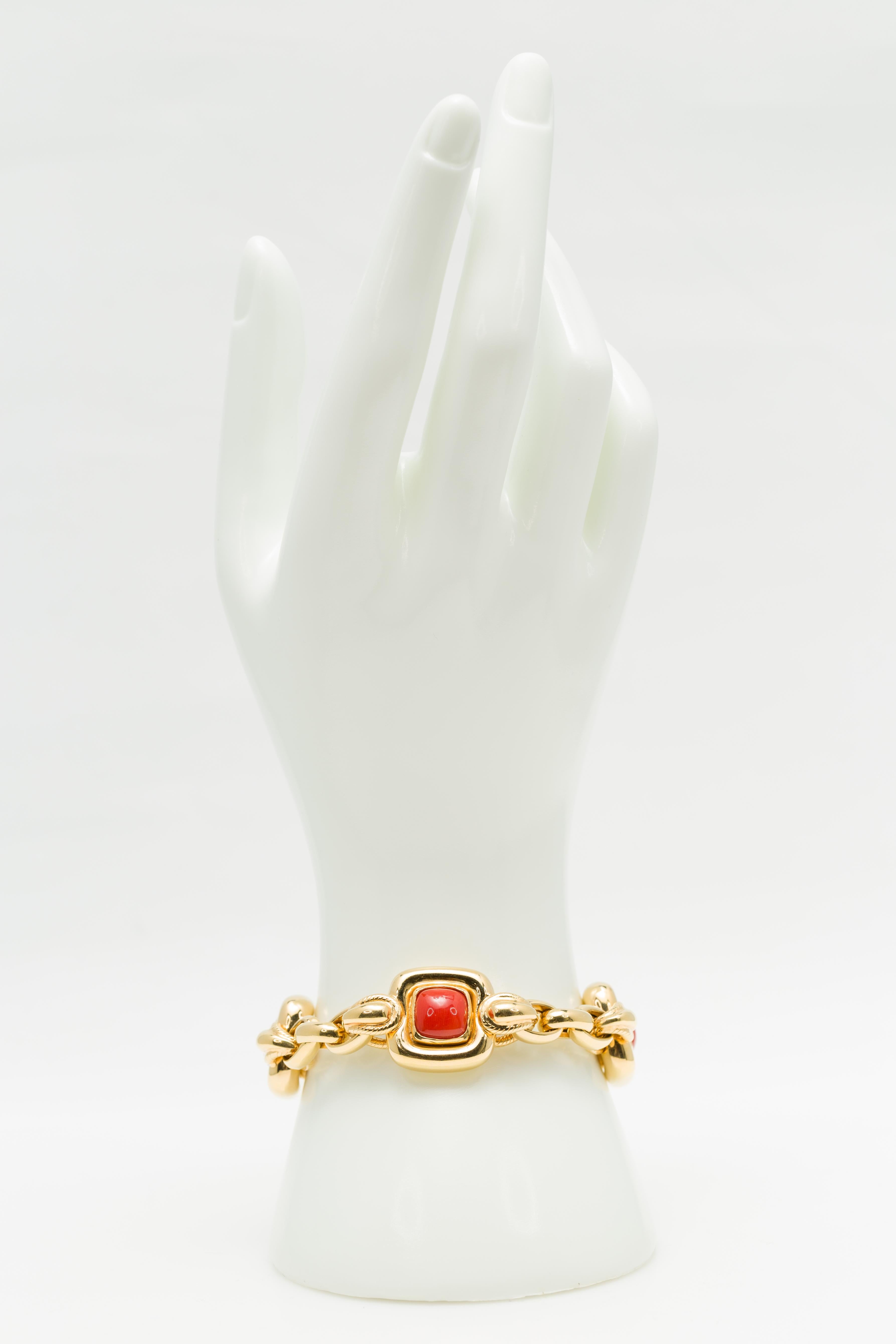 An Italian vintage cabochon Mediterranean Coral bracelet in 18K yellow gold, circa 1970. Featuring natural untreated cabochon Mediterranean Corals of a deep salmony red hue very well matched in size and color and set in 18K yellow gold, this stylish