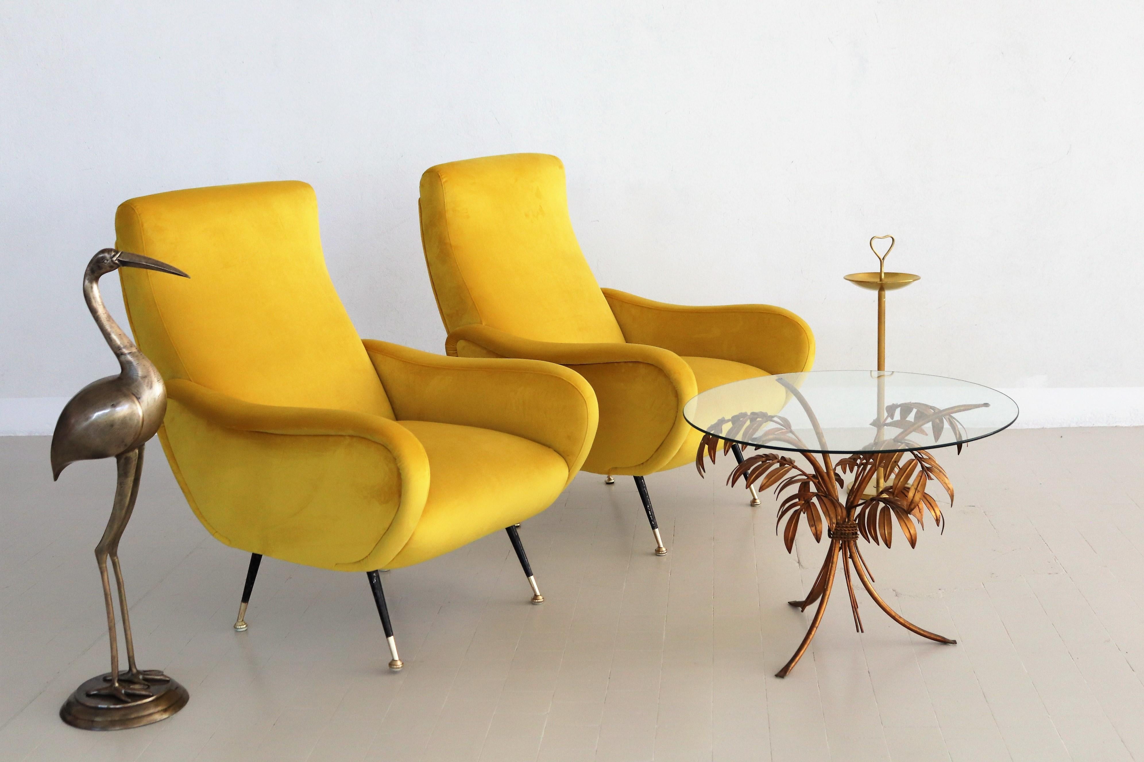 Gorgeous and colorful pair of two Italian original midcentury armchairs or lounge chairs from the 1950s with brass stiletto tips.
Completely restored internally with quality material and outside reupholstered with soft Italian velvet in sunny
