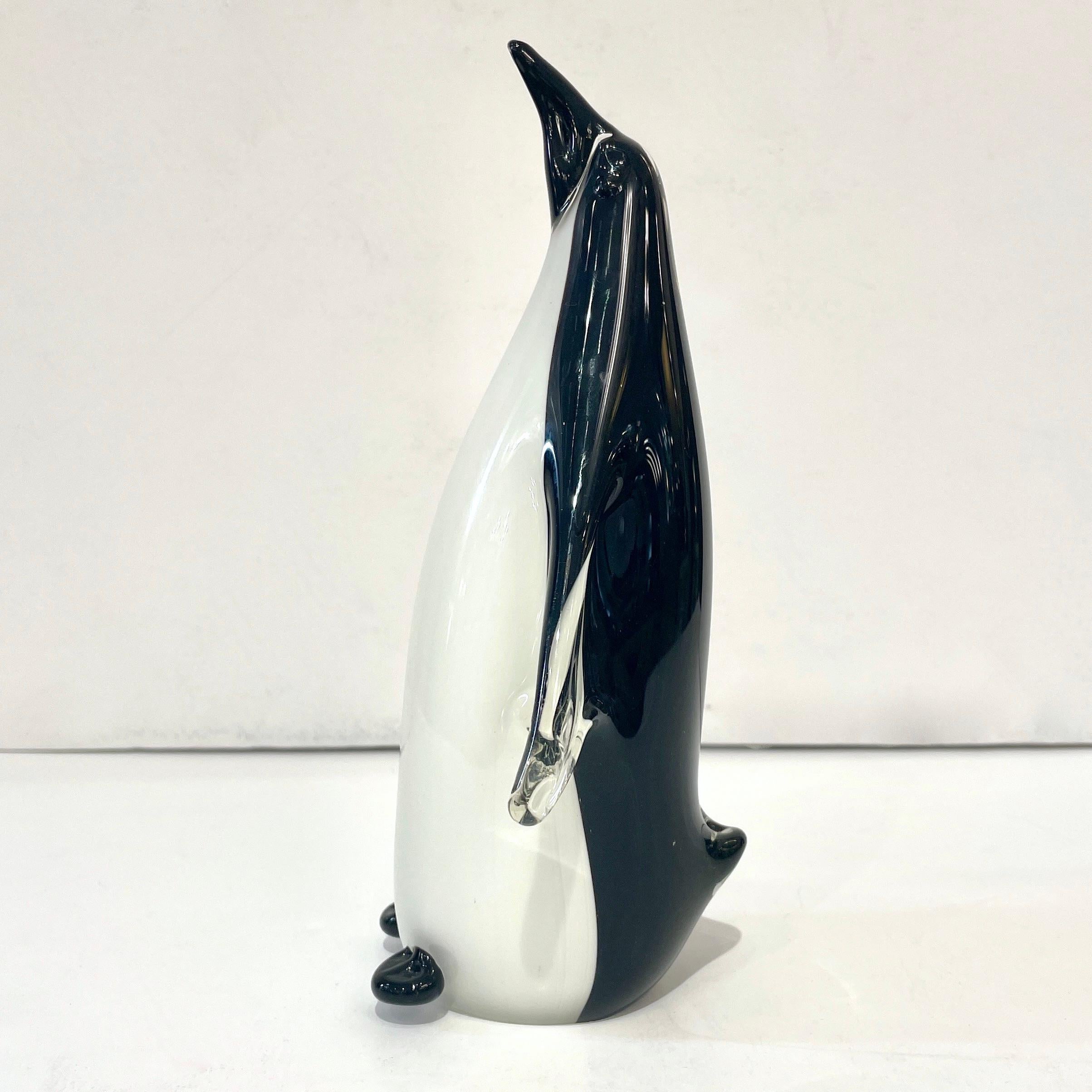 Early 1980, a very cute Venetian penguin Art sculpture in blown Murano glass, the central solid crystal clear core is deeply overlaid in black and white, to finish in crystal for the arms to confer movement and a very realistic appearance. It is a