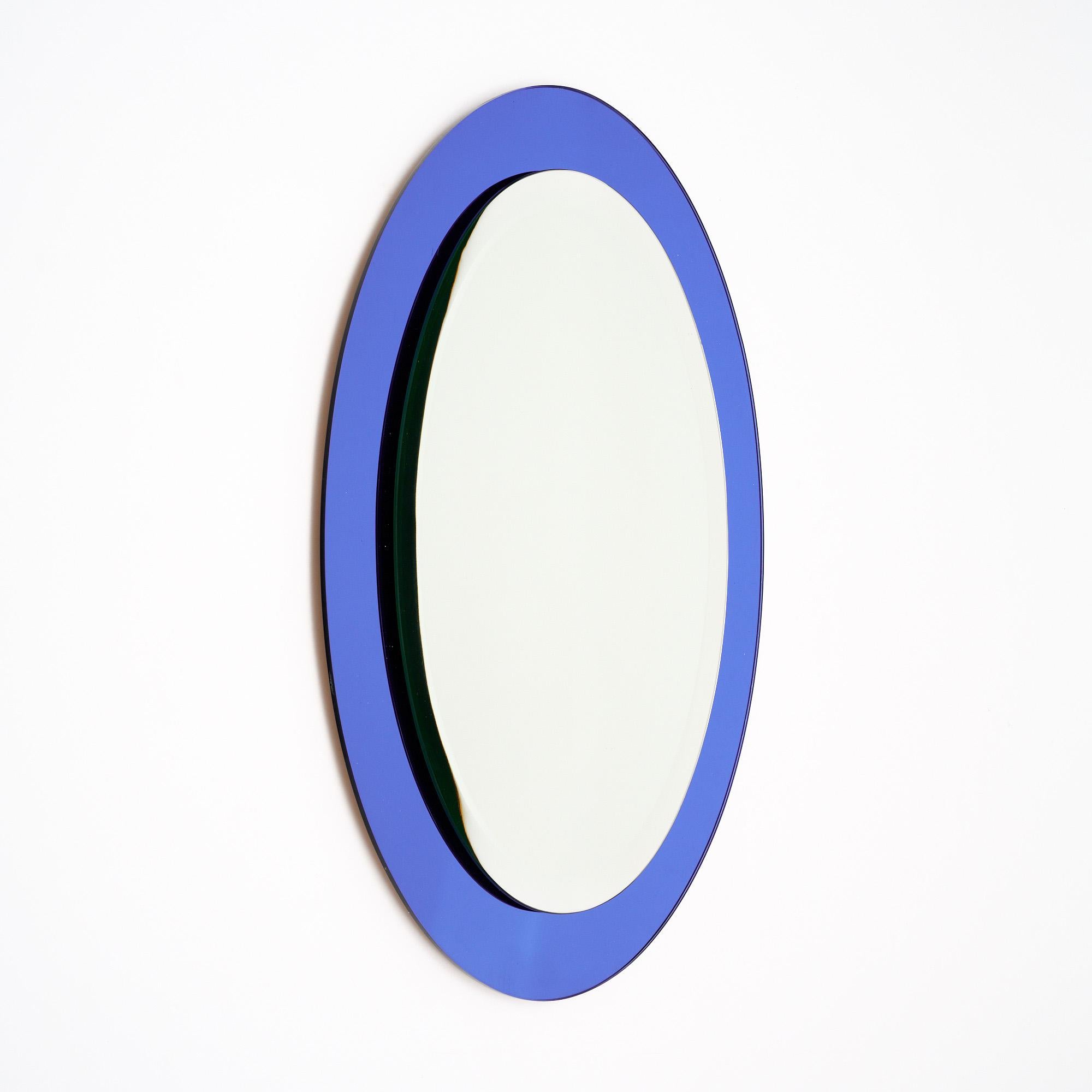 Miroir vintage d'Italie composé d'un miroir central ovale avec biseau et d'un cadre en verre bleu cobalt qui le soutient. Cette pièce est en très bon état et ne présente qu'une usure superficielle mineure due à l'âge et à l'utilisation. Les photos