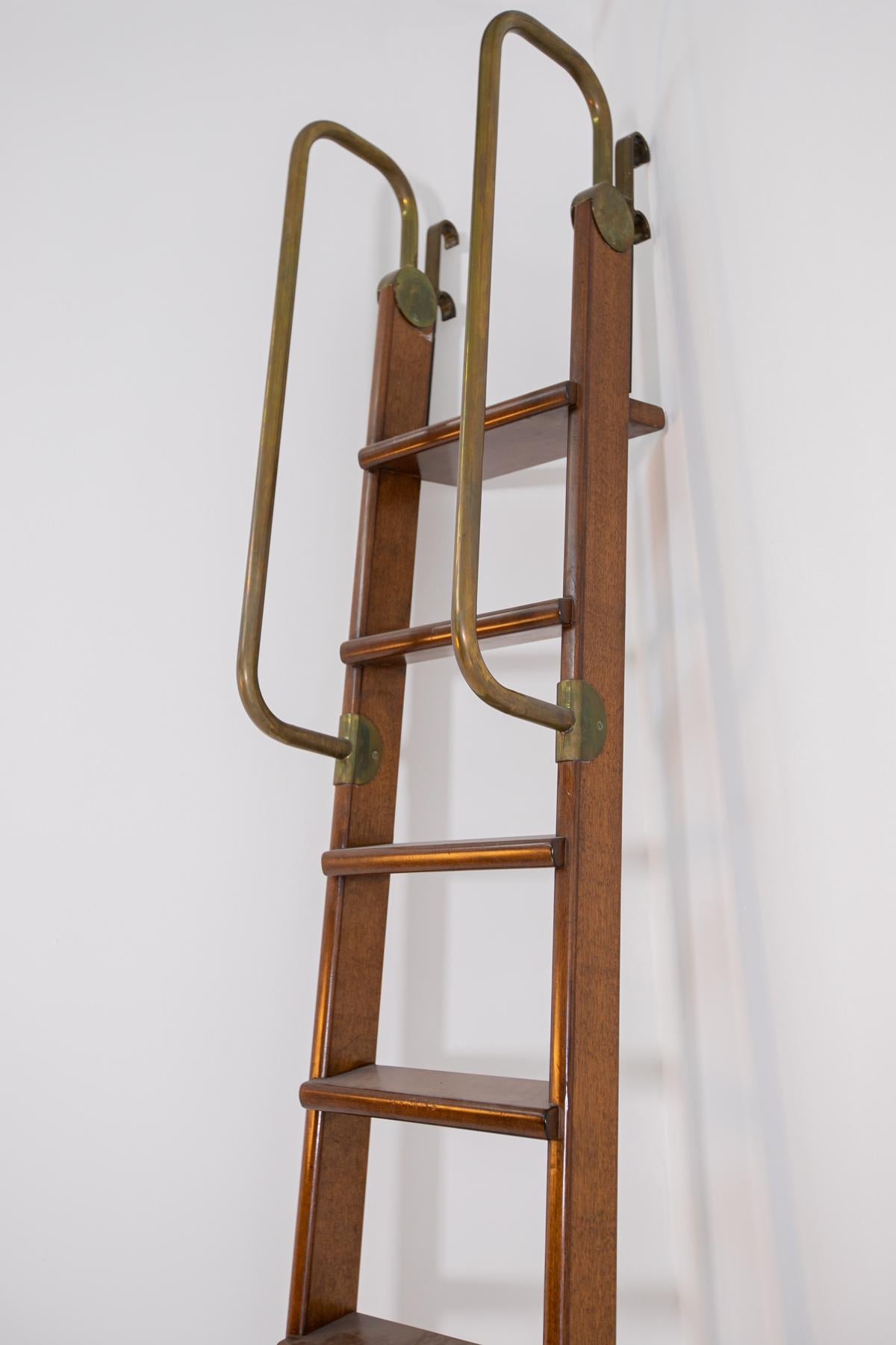 Elegante Bücherregalleiter aus italienischer Fertigung aus den 1950er Jahren. Die schöne Leiter ist aus einem massiven Nussbaumholz gefertigt und sehr solide und funktionell. 
Die Bücherregalleiter ist über zwei Rollen am Fuß der Eisenleiter