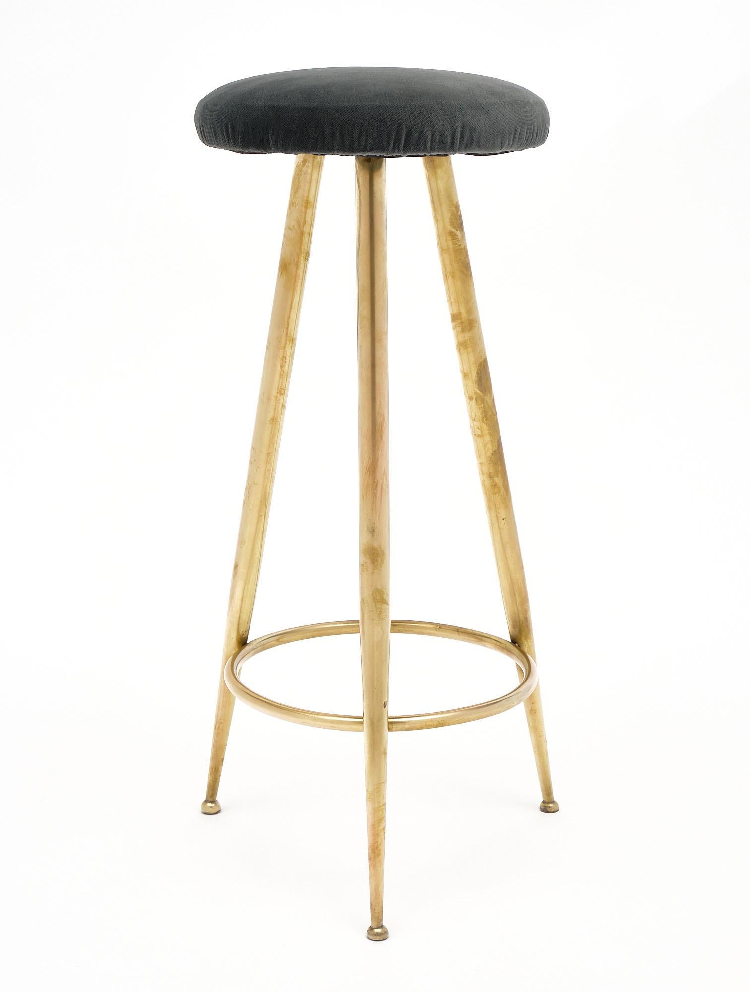 Italian tripod solid brass stool in the style of Gio Ponti. It has been newly upholstered in a gray velvet blend.