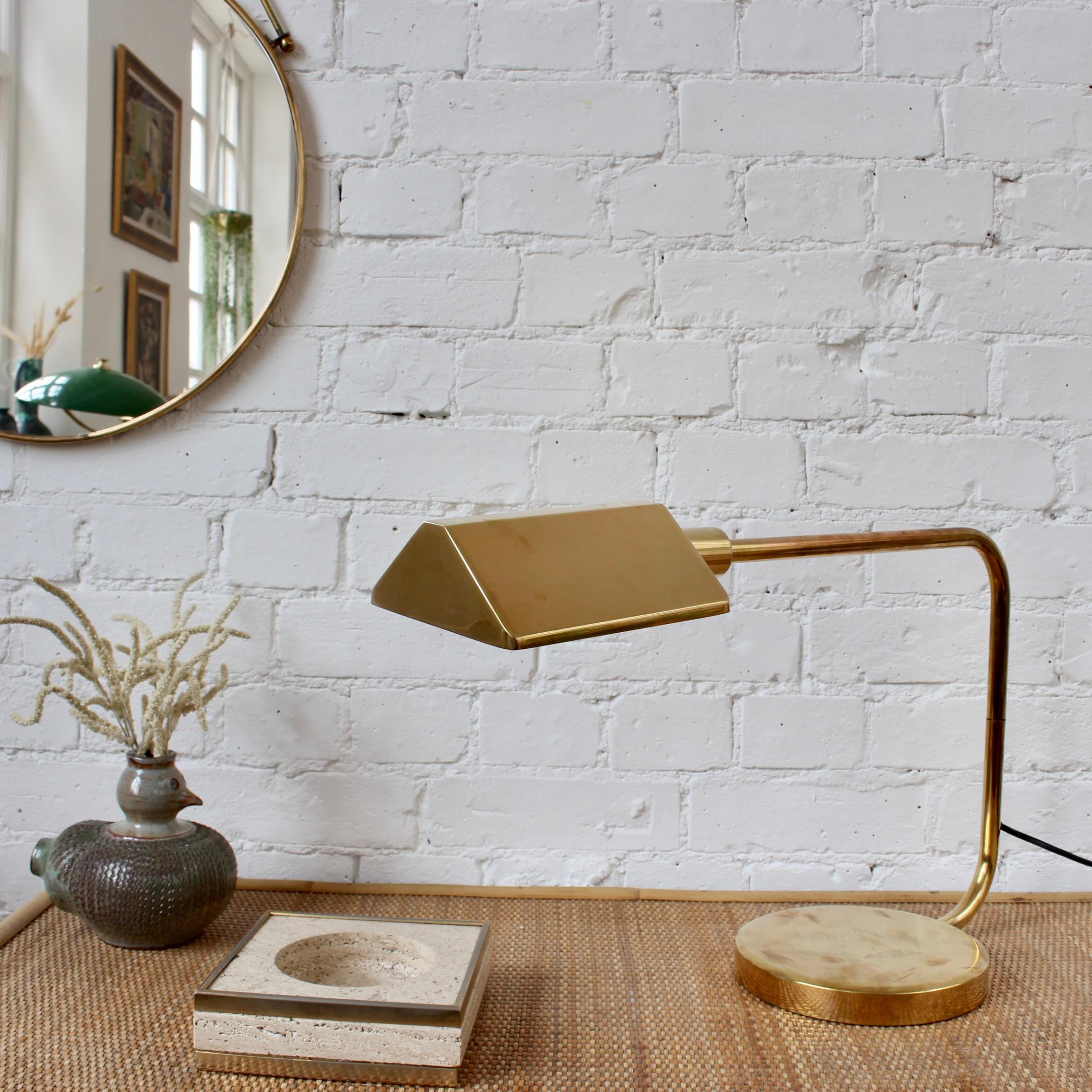 Italian vintage brass table lamp (circa 1950s). A timeless desk lamp with delightful mid-century detail including an angled arm extending from the very weighty base. The brass features a characterful aged patina throughout adding warmth to any room.