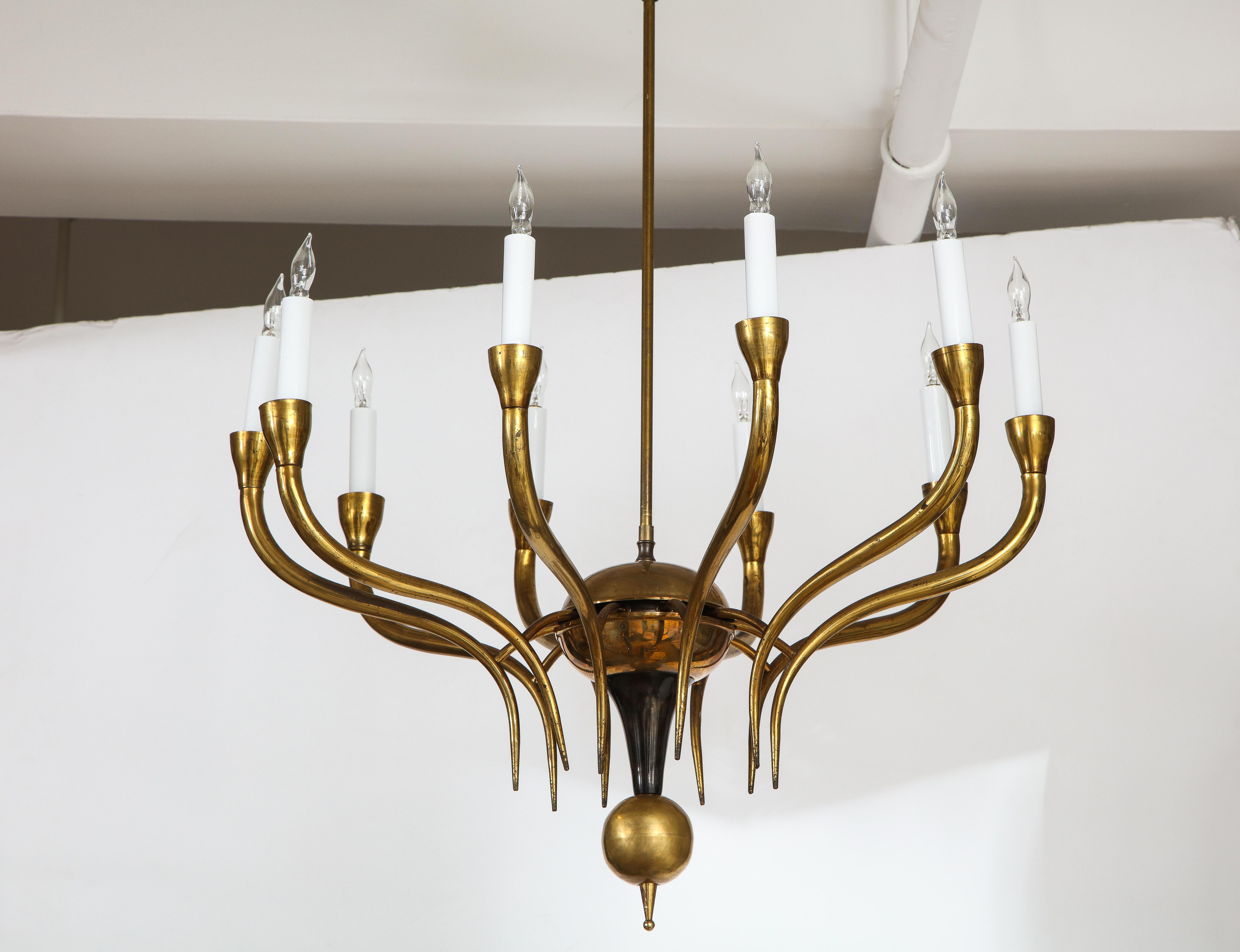 A simple and sophisticated Italian vintage brass chandelier consisting of ten elegantly outstretched arms extending from a circular central support, with a brass ball finial at its base, underneath a painted black metal geometric shape connecting