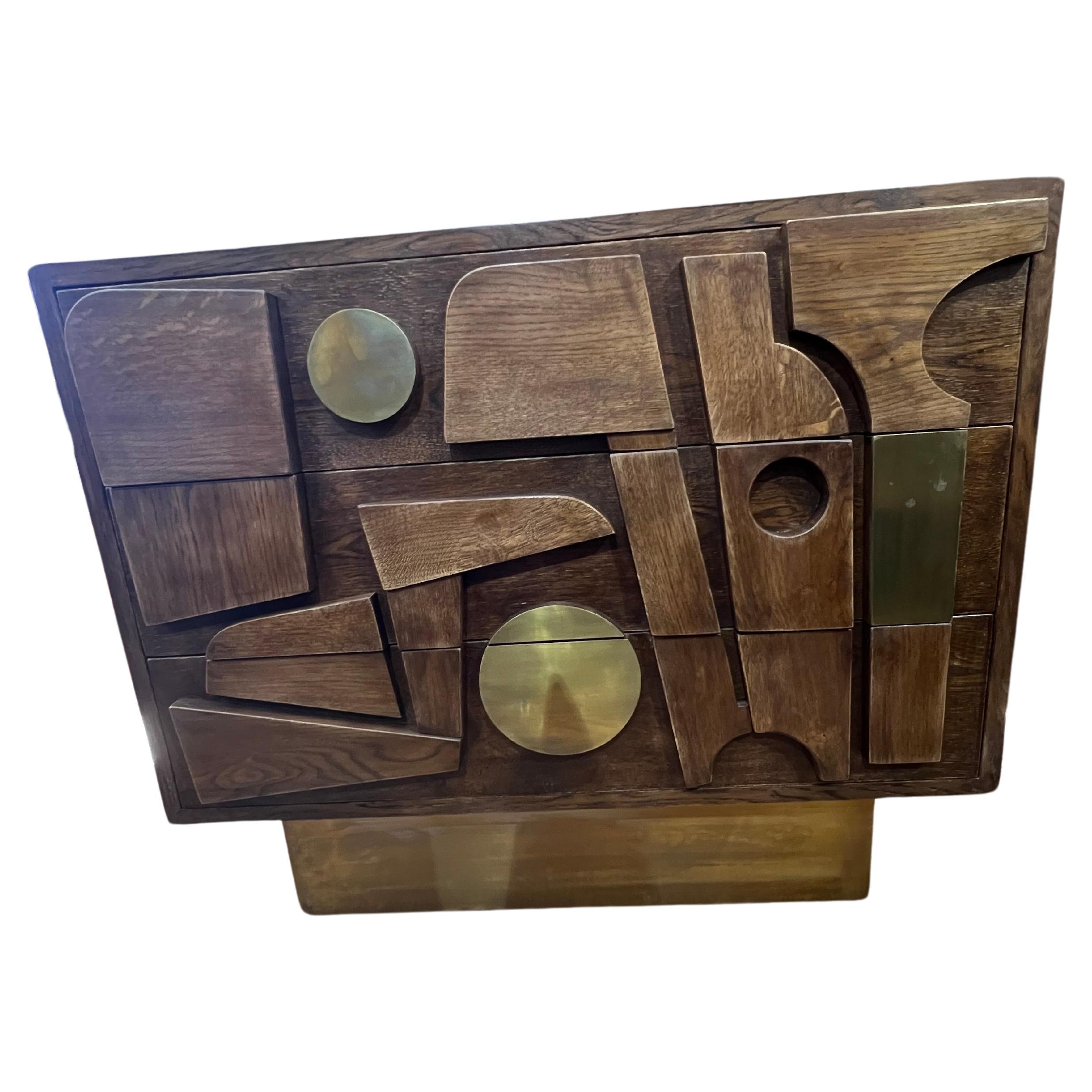 Toll aussehende italienische Vintage Kommode aus hochwertigem Eichenholz. Top ist Display schöne Holzmaserung. Die Kommode hat 3 geräumige Schubladen und ruht auf einem rechteckigen Messingsockel. Die Front der Schubladen ist mit geometrischen