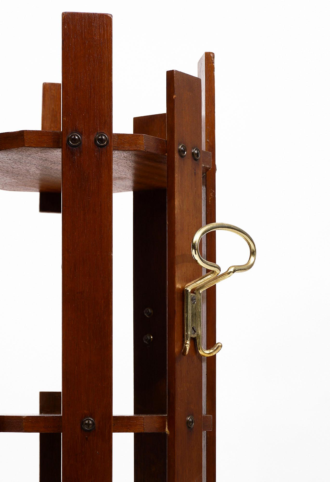 Italian vintage coat rack in the style of Carlo di Carli crafted of solid mahogany featuring seven shelves and solid gilt brass hooks.