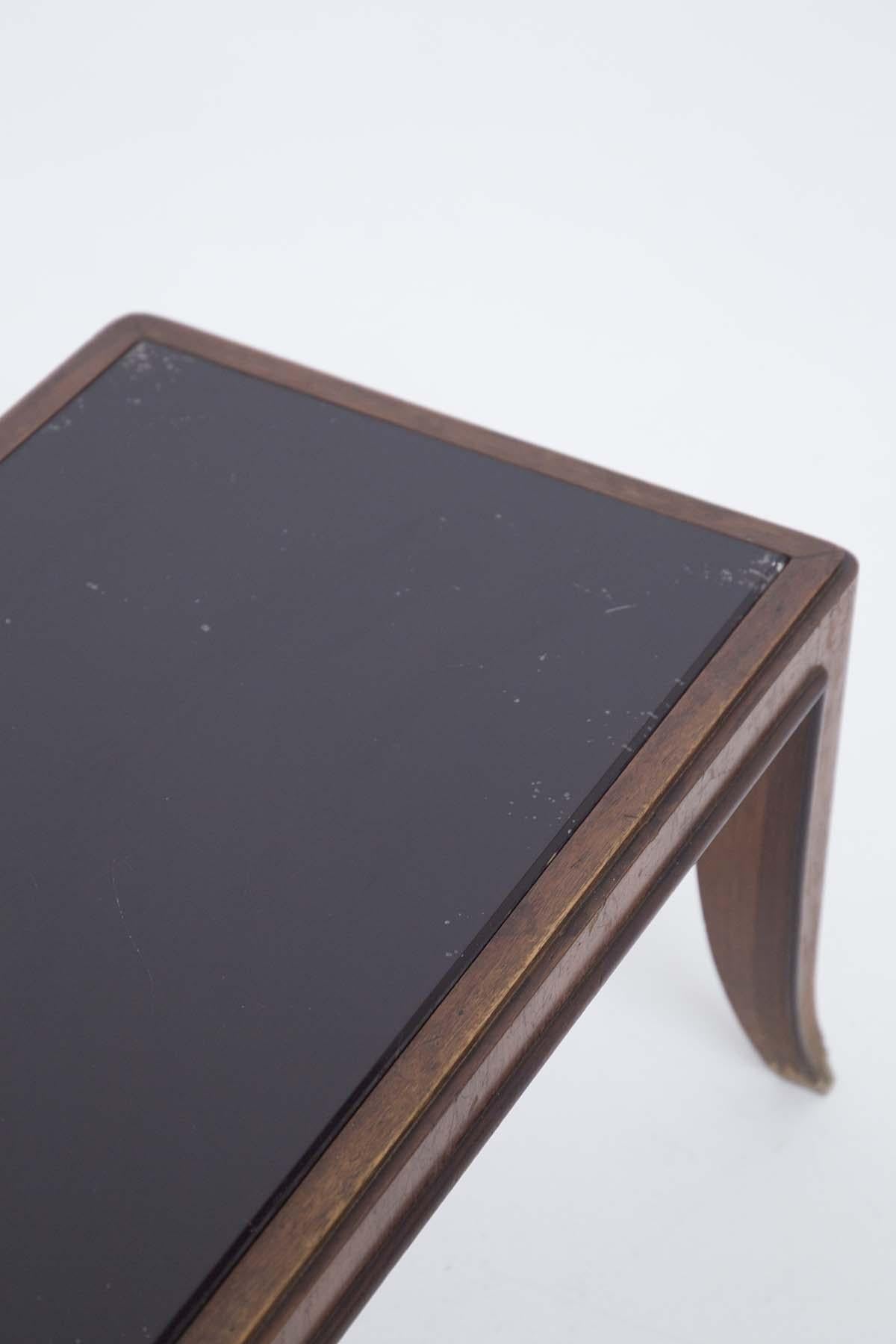 Niedriger Couchtisch, der Gio Ponti zugeschrieben wird, entworfen in den 1950er Jahren. Der niedrige Tisch hat eine vollkommen intakte dunkle Glasplatte. Der Rahmen ist aus sehr starkem Holz gefertigt. Die Struktur des Tisches ist von gut