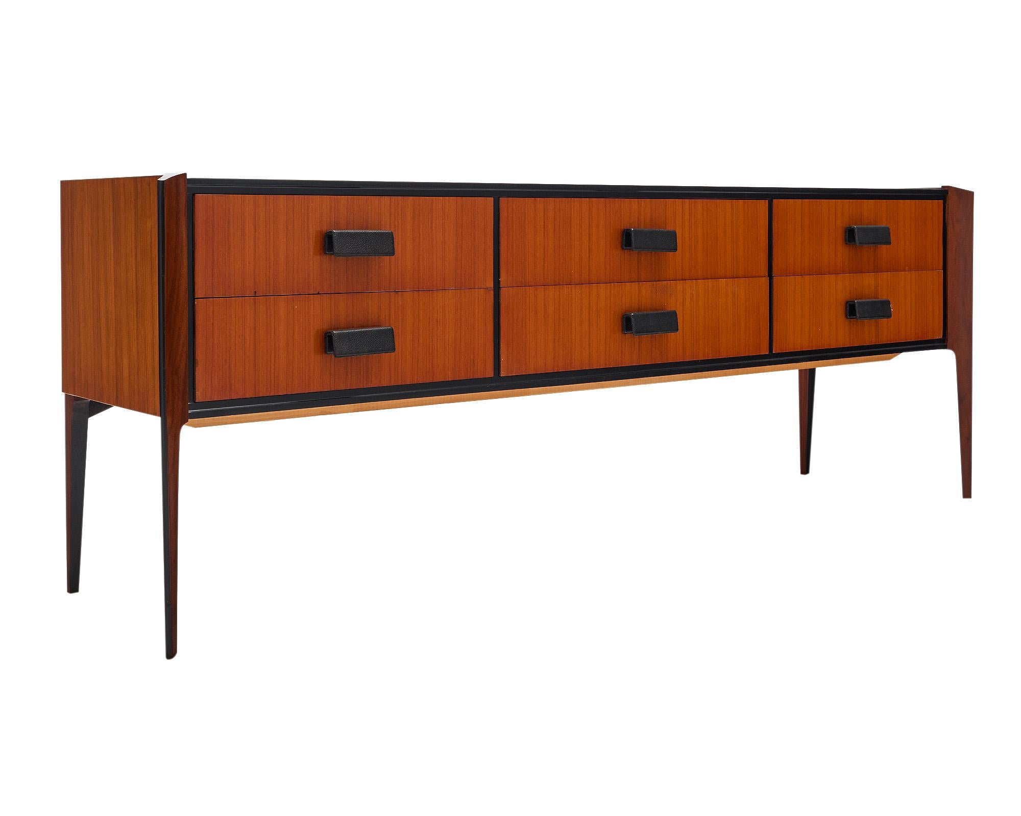 Chest or console case piece from Italy in the mid-century style. This chest features beautiful teak wood with unique tapered legs. There are six dovetailed drawers with leather wrapped pulls on each.