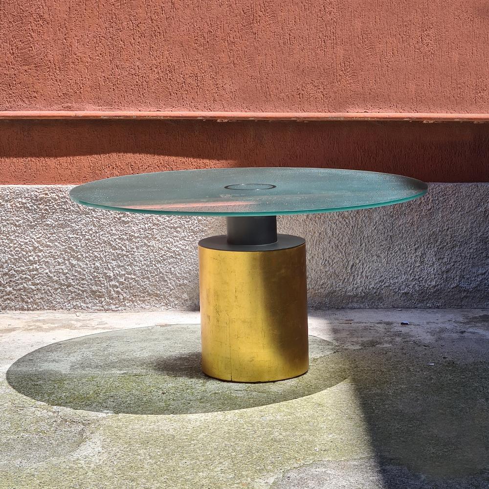 Italian vintage Creso round table by Massimo & Lella Vignelli for Acerbis, 1980s
Round dining table, Creso model, with opalescent glass top with low side of the top in satin finish and cylindrical base covered with gold leaf.
Project by Lella &