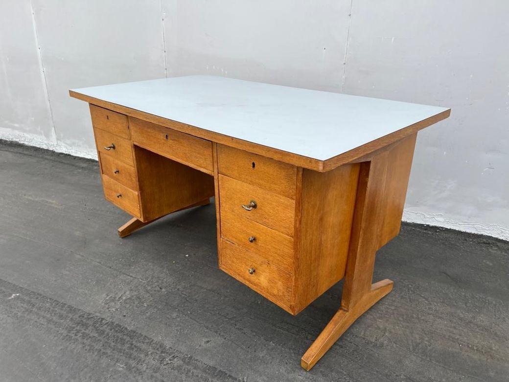 Italian mid century desk in style of Anonima Castelli. Top is Formica, Oak veneer total of nine drawers with the brass hardware.