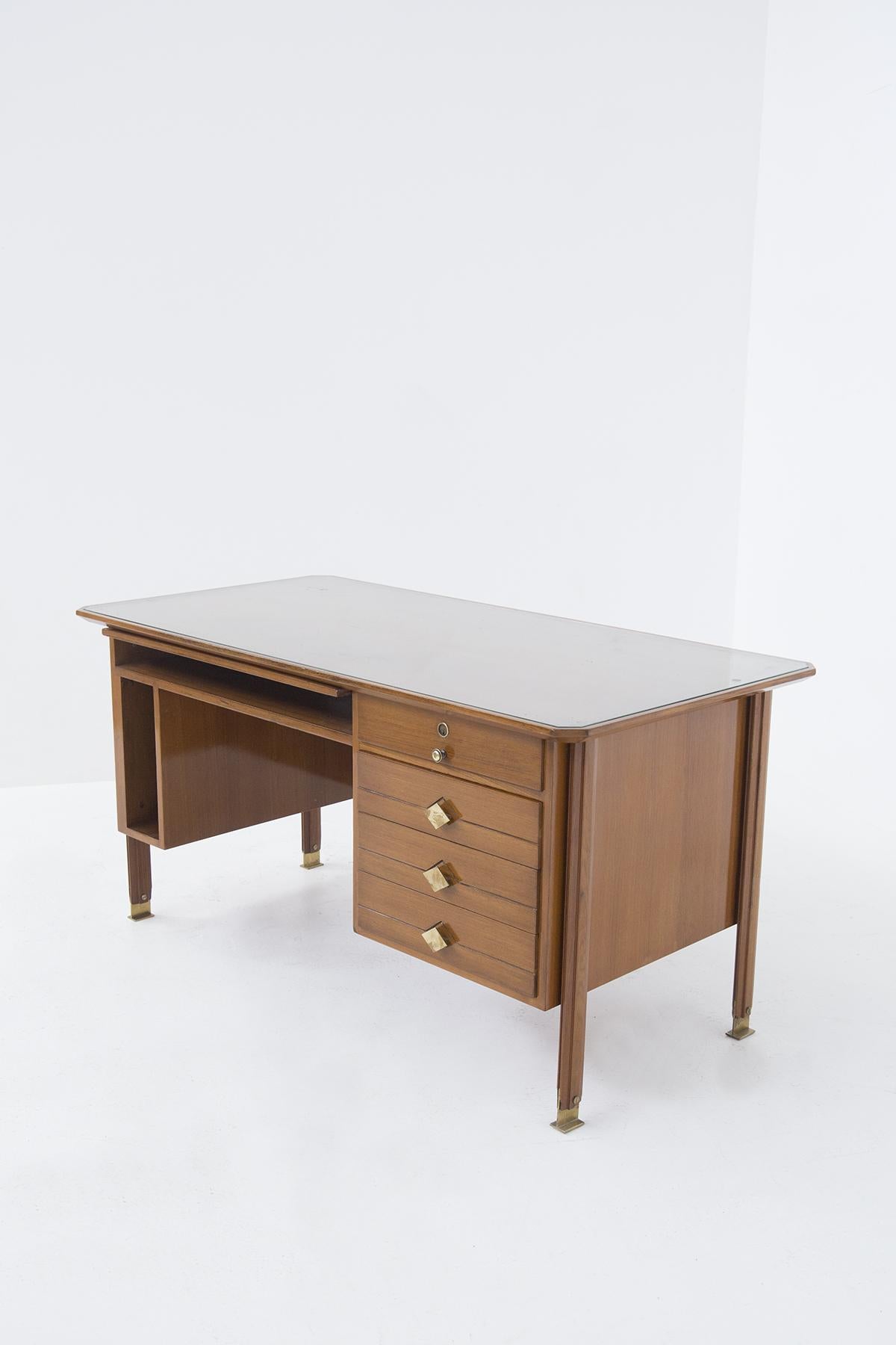 The beautiful desk is made in walnut wood, but the top is covered with glass plate giving the dest and elegant look. The desk features four drawers, one of which can be closed with a key. The drawers have brass knobs, one cylindrical while the