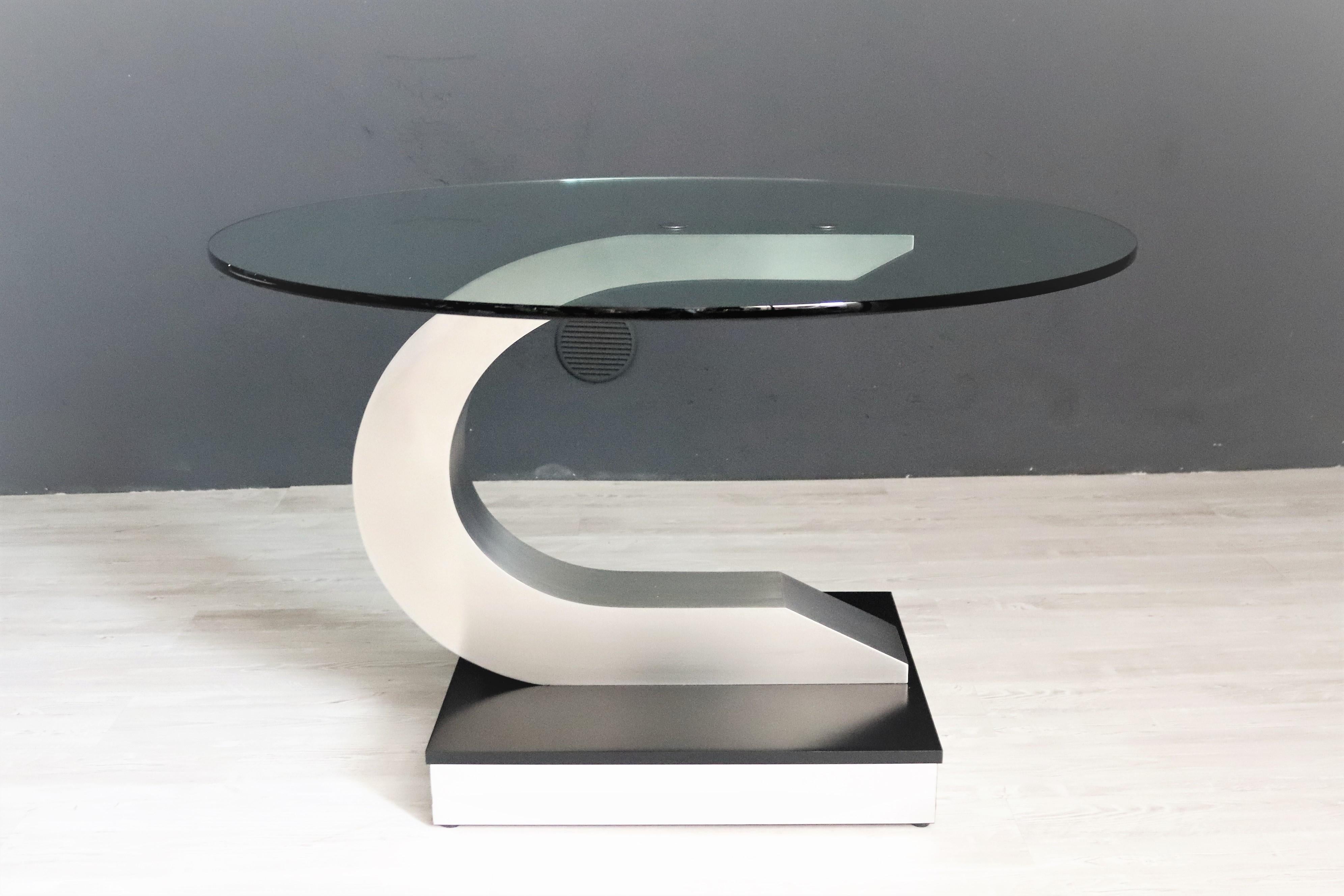 Magnificent round dining table with thick crystal glass in the style of Pierre Cardin.
Made in Italy during the 1970s.
The table base is made of strong stainless steel on wooden lacquered black base, whilst the glass top is mounted with two thick