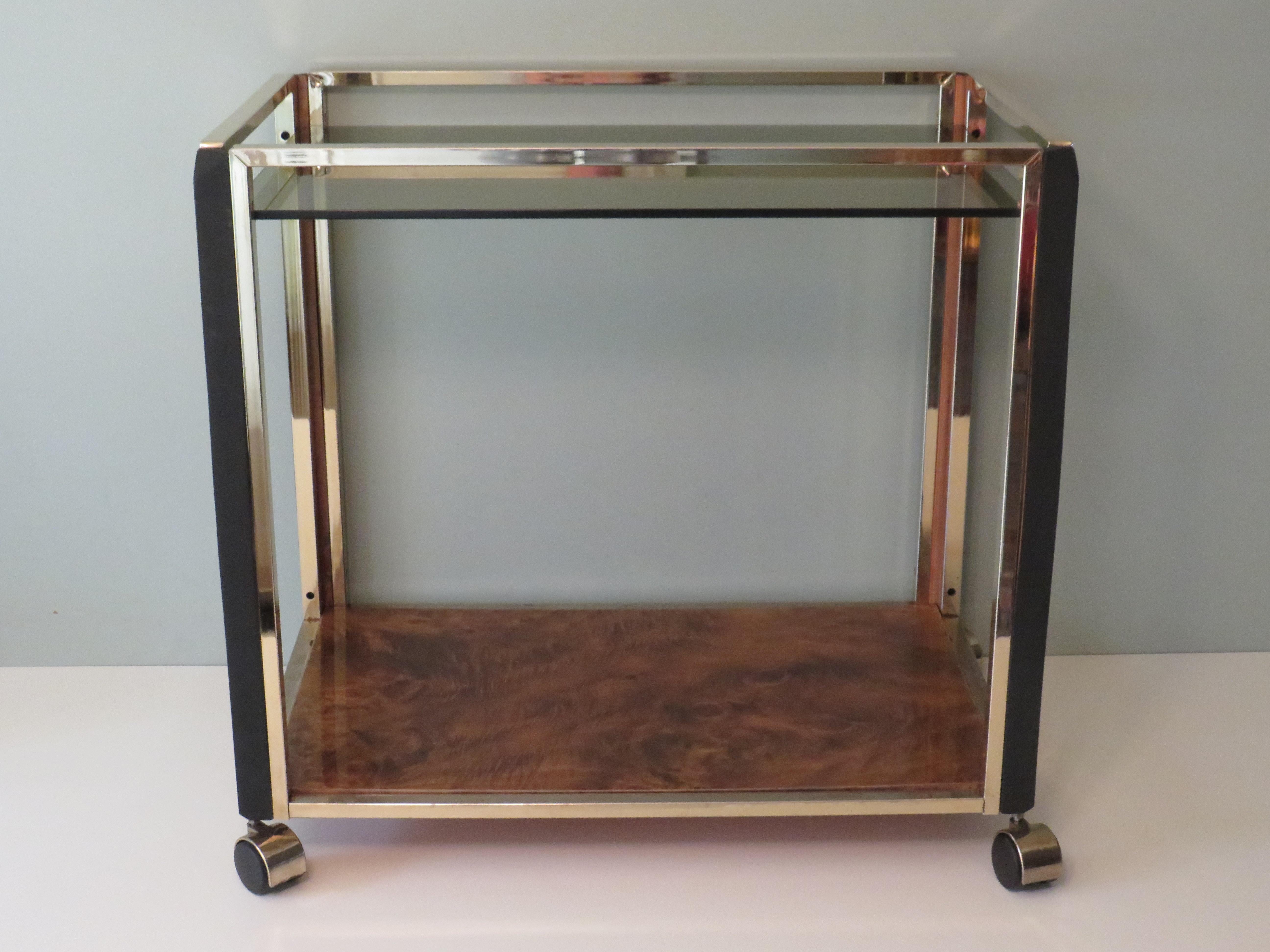 The trolley has a gold-plated frame.
The corners of the trolley are made of black (mat) lacquered wood.
The lower top has a burlwood veneer layer.
The top is made of fumed glass with a thickness of 8 mm.