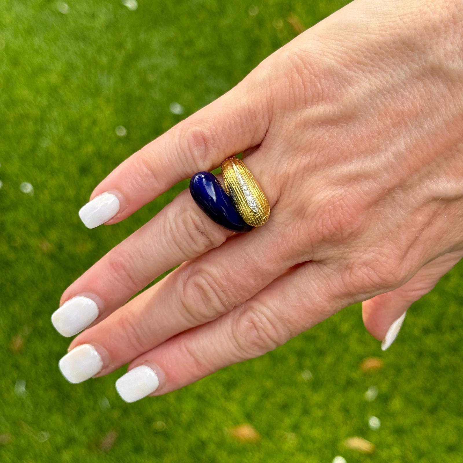 This exquisite vintage Italian ring showcases a sophisticated bypass design, crafted in luxurious 18 karat yellow gold. The ring features vibrant blue enamel accents that gracefully swirl around the finger, creating a striking visual contrast