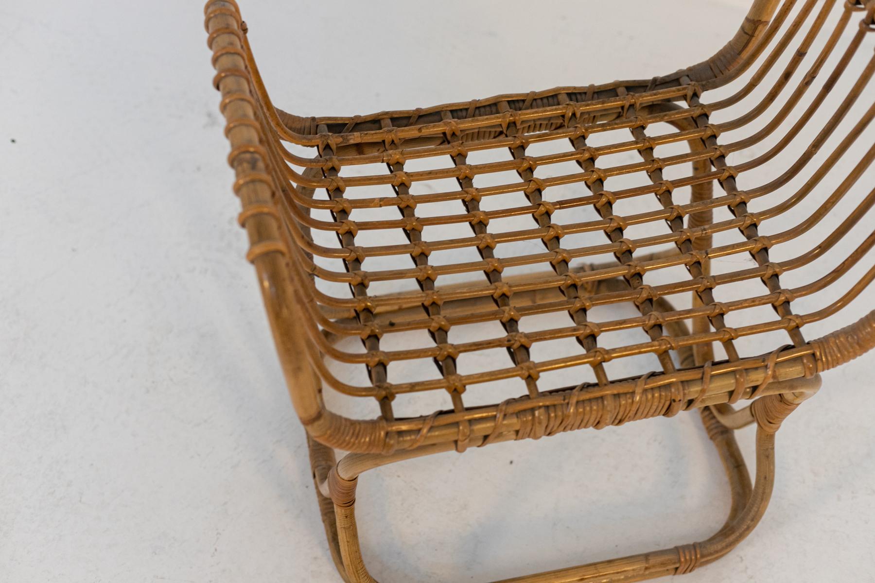 Particular vintage Italian bamboo and rattan footstool designed in the 50s. 
The footstool has a sinuous and soft shape, the structure is completely made of durable bamboo, the legs cross to create soft and decorative lines. 
The seat is made