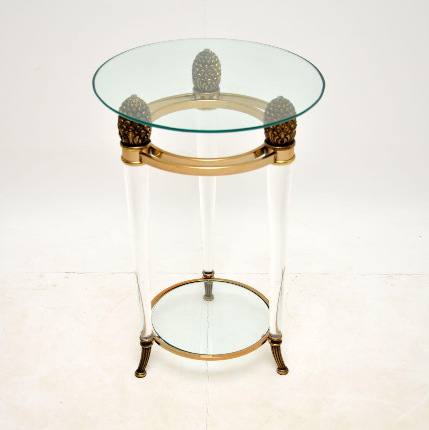 A stylish and useful vintage side table, this was made in Italy and dates from the 1970’s.

The frame is made from thick clear acrylic, with brass feet and pine cone shaped supports. There are brass plated rings at the bottom and top, and this has