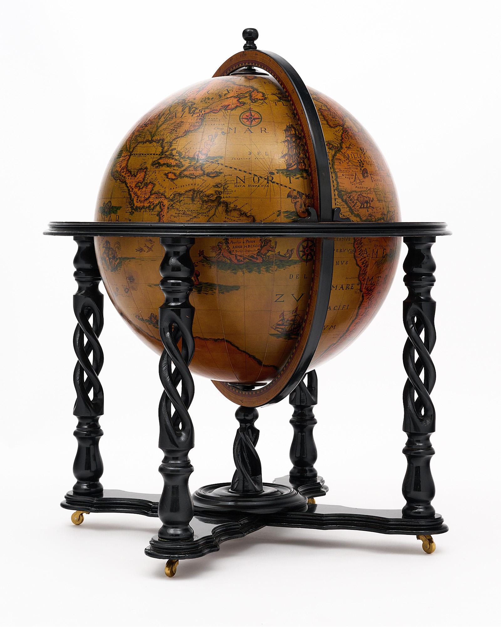 Globe, Italian, with hand-painted decor from the 20th century in Italy. The globe rotates and is supported by an intricate, hand-carved and ebonized four legged structure on casters. The globe opens up to a fully featured bar with bottle holders.