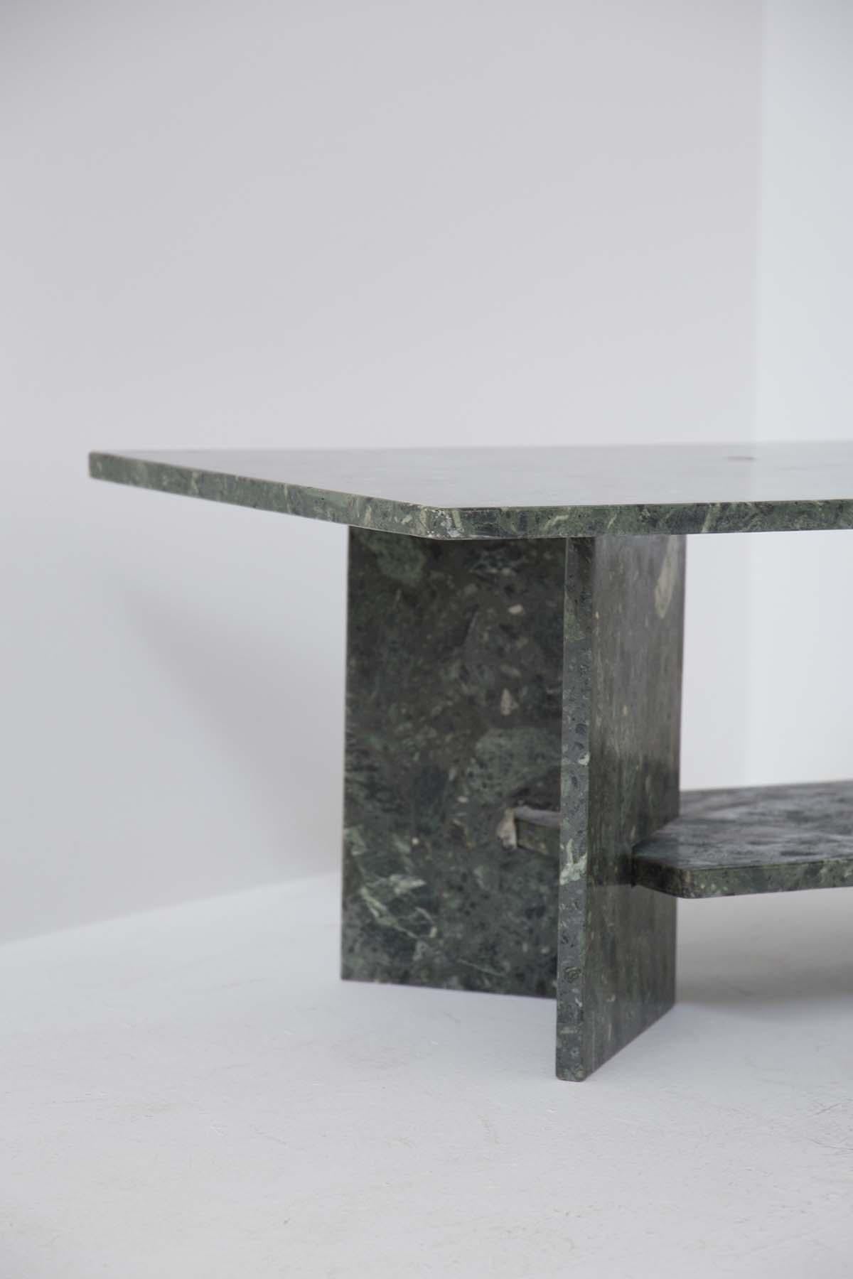 Gorgeous marble coffee table of fine Italian manufacture from the 1970s. The table is made entirely of green alps marble. The top is rectangular with two legs supporting the top, creating a V shape. In the middle of the two legs is inserted a second