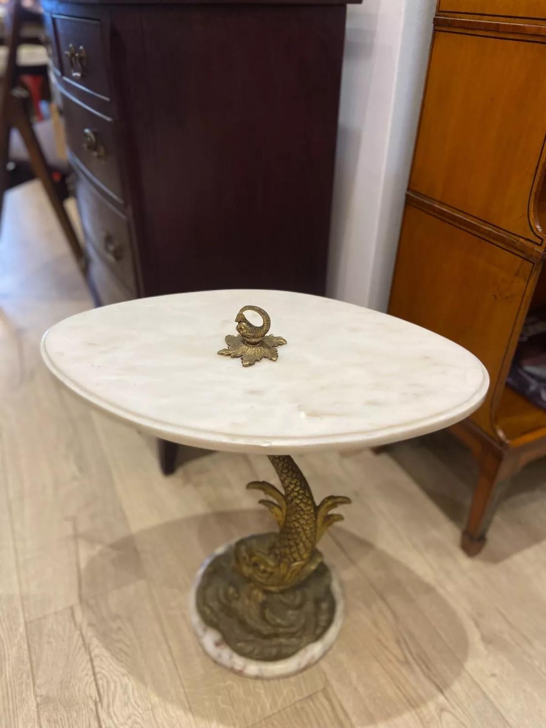 A vintage Hollywood regency style Italian white marble top side table set on a brass dolphin stem and a marble base.

Dimensions:

Width :  55 cm
Height : 52.5 cm
Depth :  31 cm 