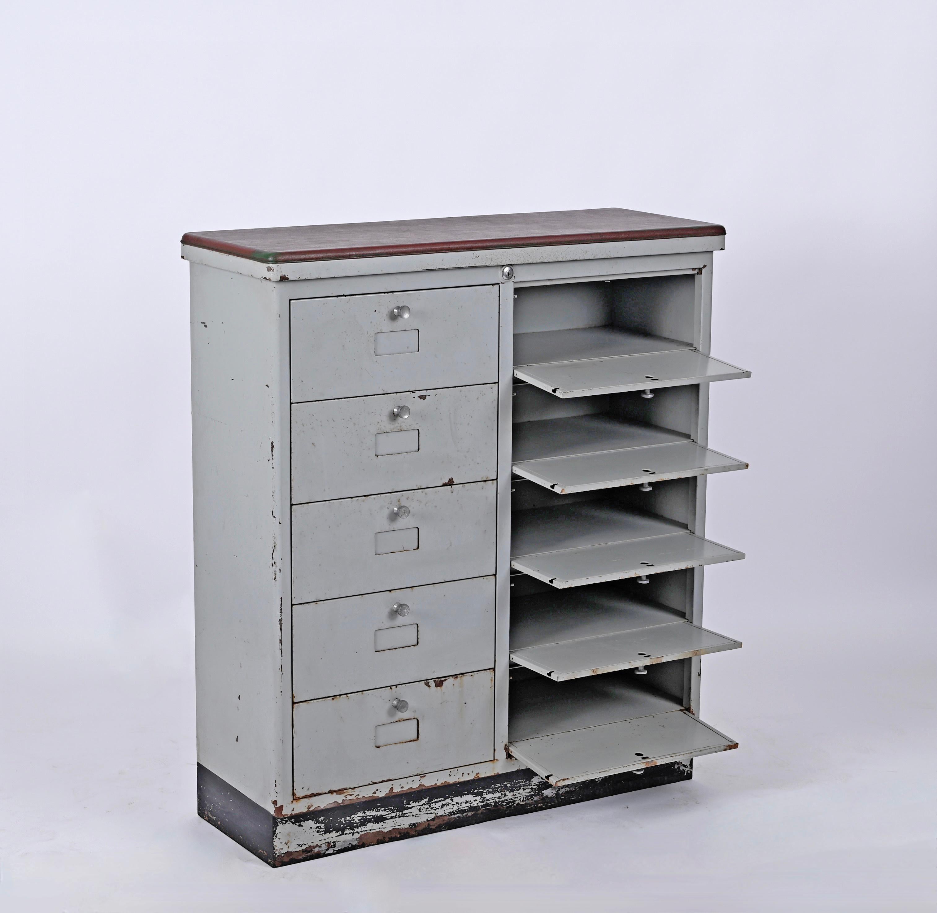 Beautiful original industrial cabinet with ten drawers, 1950s. This amazing piece was manufactured in Italy during the 1950s.

The cabinet features 10 drawers with beautiful carved knobs and a top enriched by a dark burgundy leather. 
In great