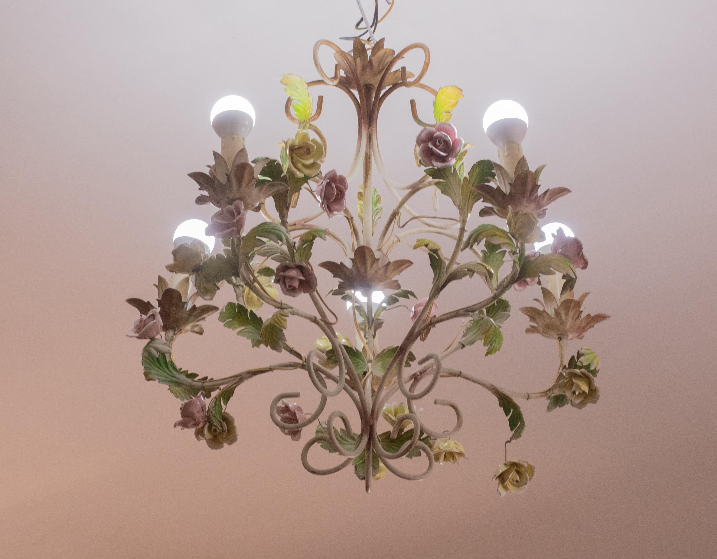 Vintage Italian painted iron chandelier with ceramic flowers.

Period circa 1970s

The chandelier has a painted iron frame and is decorated with beautiful handmade ceramic flowers.

The light mounts 5 e14 lamp holders, European