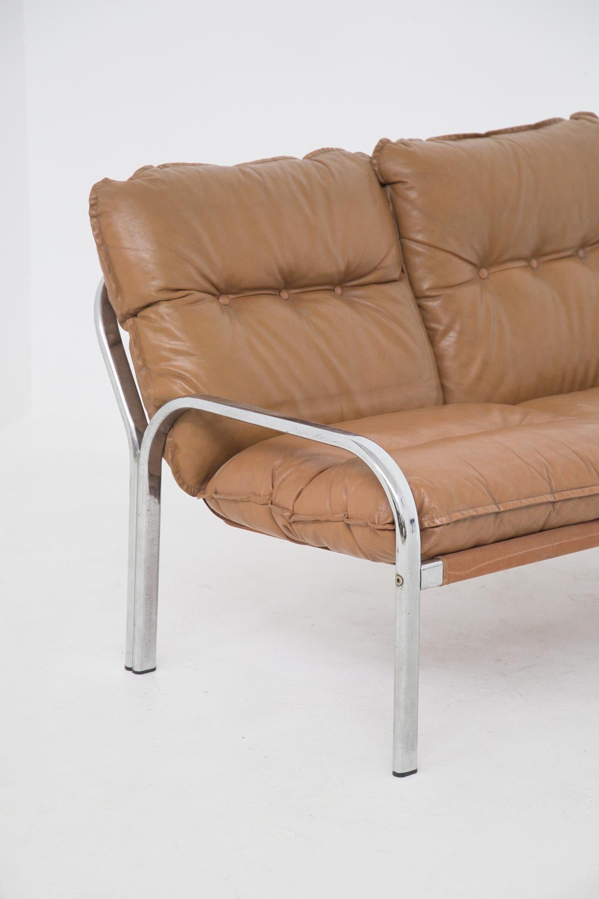 Two-seat leather sofa attributed to the magnificent designer Gae Aulenti, of fine Italian manufacture, from the Space Age period.
The sofa has a supporting structure totally made of steel. The 4 supporting legs are connected to each other in pairs