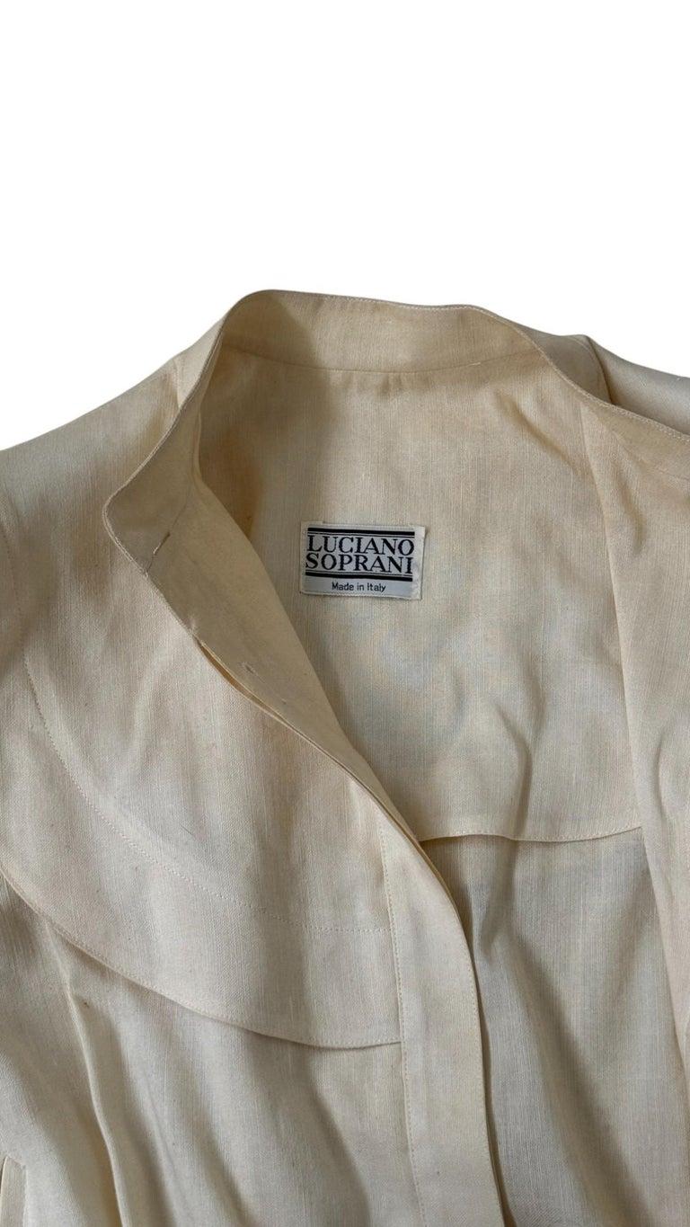 Pièce rare et raffinée du début des années 1980, cette blouse vintage de Luciano Soprani reflète parfaitement le mélange de sophistication et de structure propre au créateur italien. Fabriquée en Italie, cette blouse est réalisée en lin naturel ou