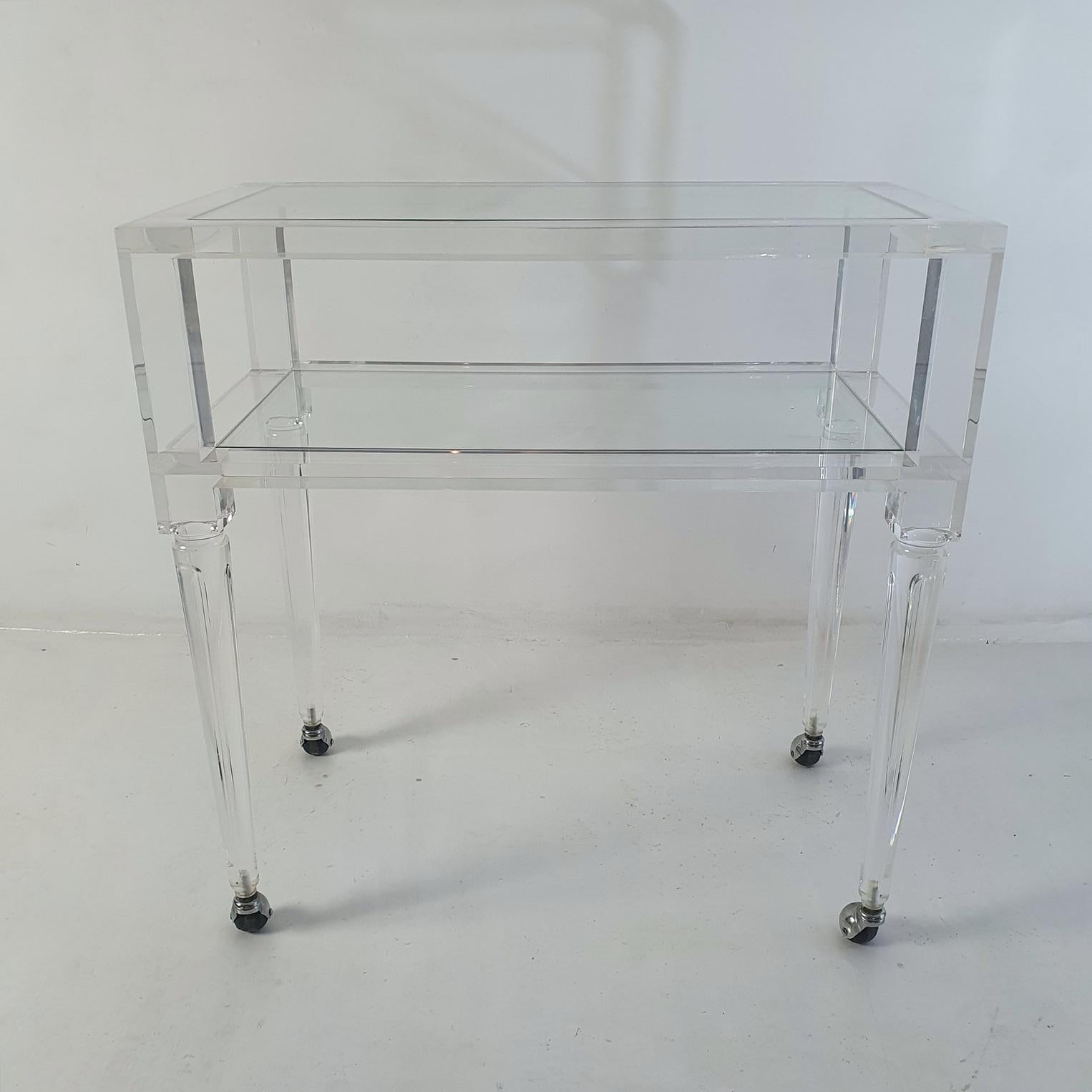 A two tiered bar cart in in lucite/plexiglass with shelves in glass. In very good condition and very stabile. It also is easy to move with the castors working very well. Very nice condition and minimal wear to the lucite.
Perfect as a bar or a side