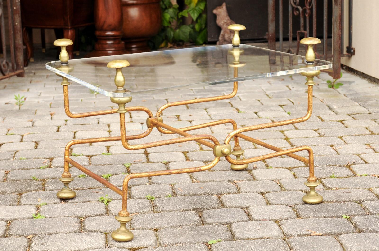 An Italian vintage brass cocktail table from the mid-20th century, with Lucite top. Born in Italy during the midcentury period, this cocktail table features a rectangular Lucite top, accented with eye-catching finials in its corners. The table is