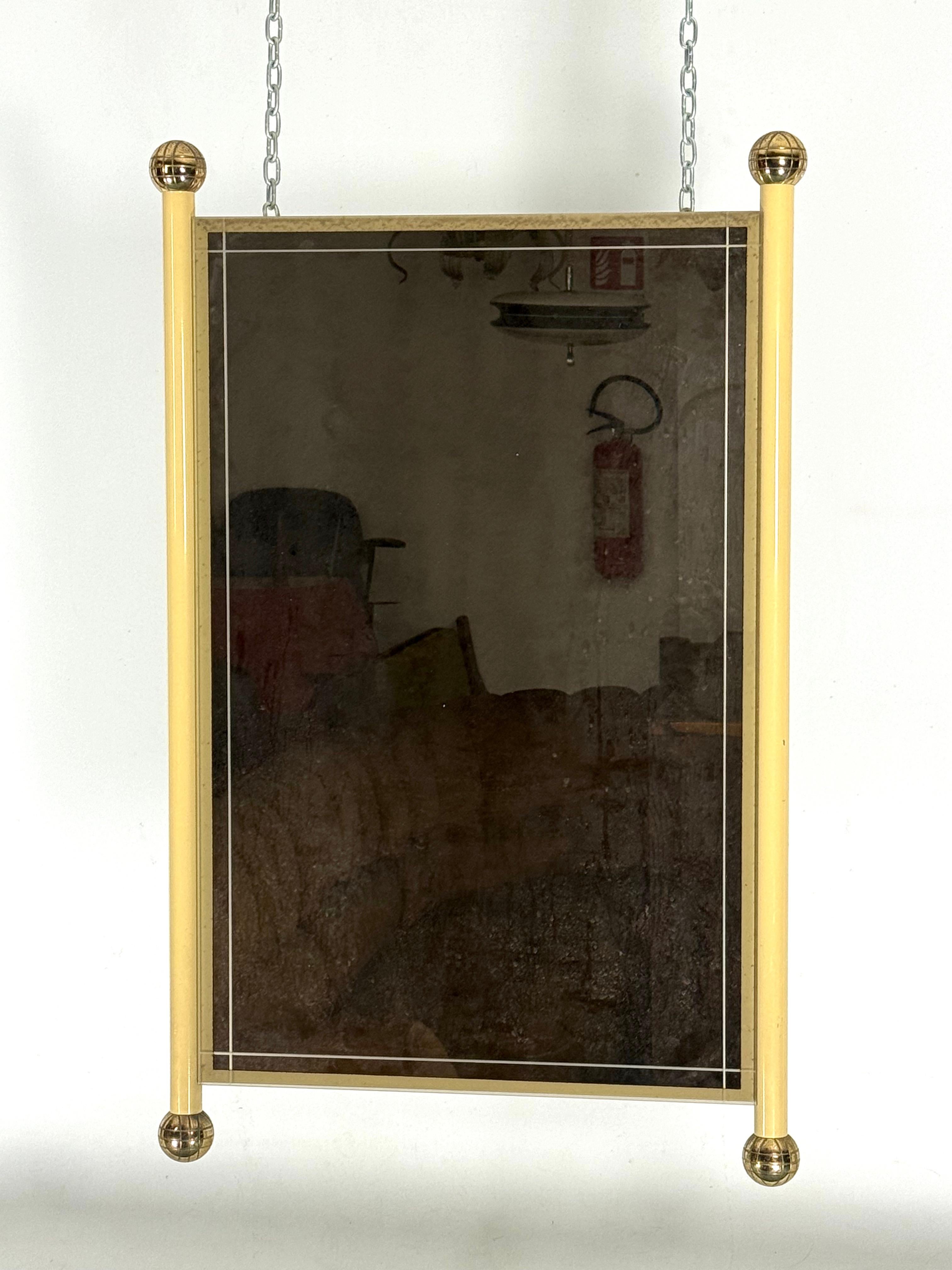 Fair vintage condition with slight trace of age and use for this mirror in the style of Tommaso Barbi. Made from brass, lacquered brass and bronzed mirror.
