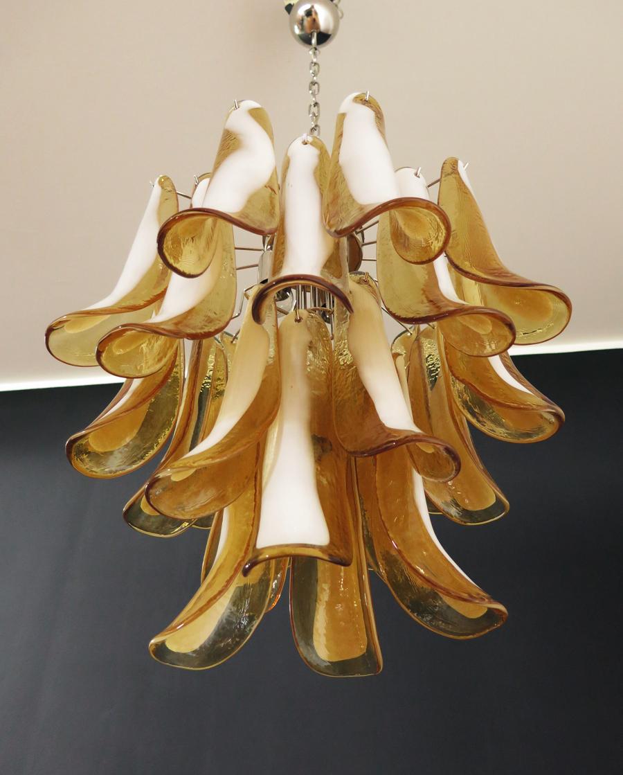 Italian vintage Murano chandelier made by 26 glass petals (amber and white “lattimo”) in a chrome frame.
Period: 1980s
Dimensions: 47.250 inches (120 cm) height with chain; 23.62 inches (60 cm) height without chain; 19.70 inches (50 cm)