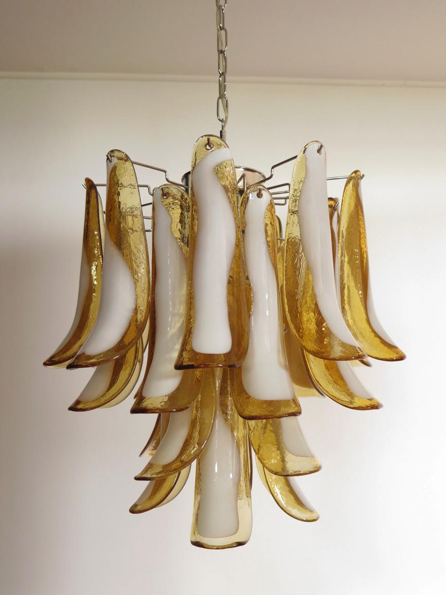 Italian vintage Murano chandelier made by 26 glass petals (amber and white “lattimo”) in a chrome frame.
Period: late XX century 
Dimensions: 47,250 inches (120 cm) height with chain; 23,62 inches (60 cm) height without chain; 19,70 inches (50 cm)
