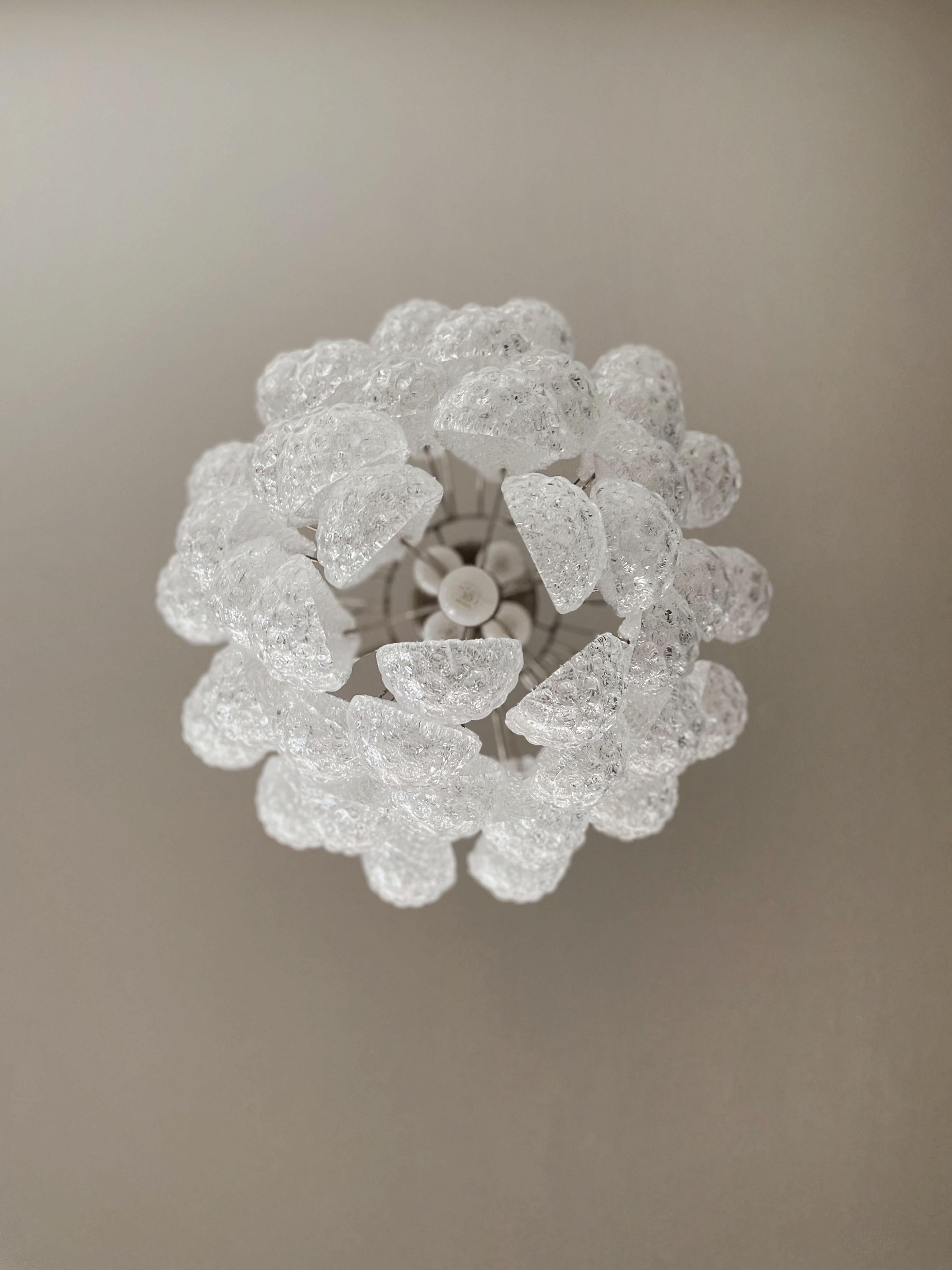 Italienischer Vintage Murano Kronleuchter aus 41 Glasblättern (transparentes Kristall, außen glatt, mit Kristallpulver und dann innen rau.) in einem Chromrahmen.
Zeitraum: Ende des XX. Jahrhunderts
Abmessungen: 49,20 Zoll (125 cm) Höhe mit Kette;