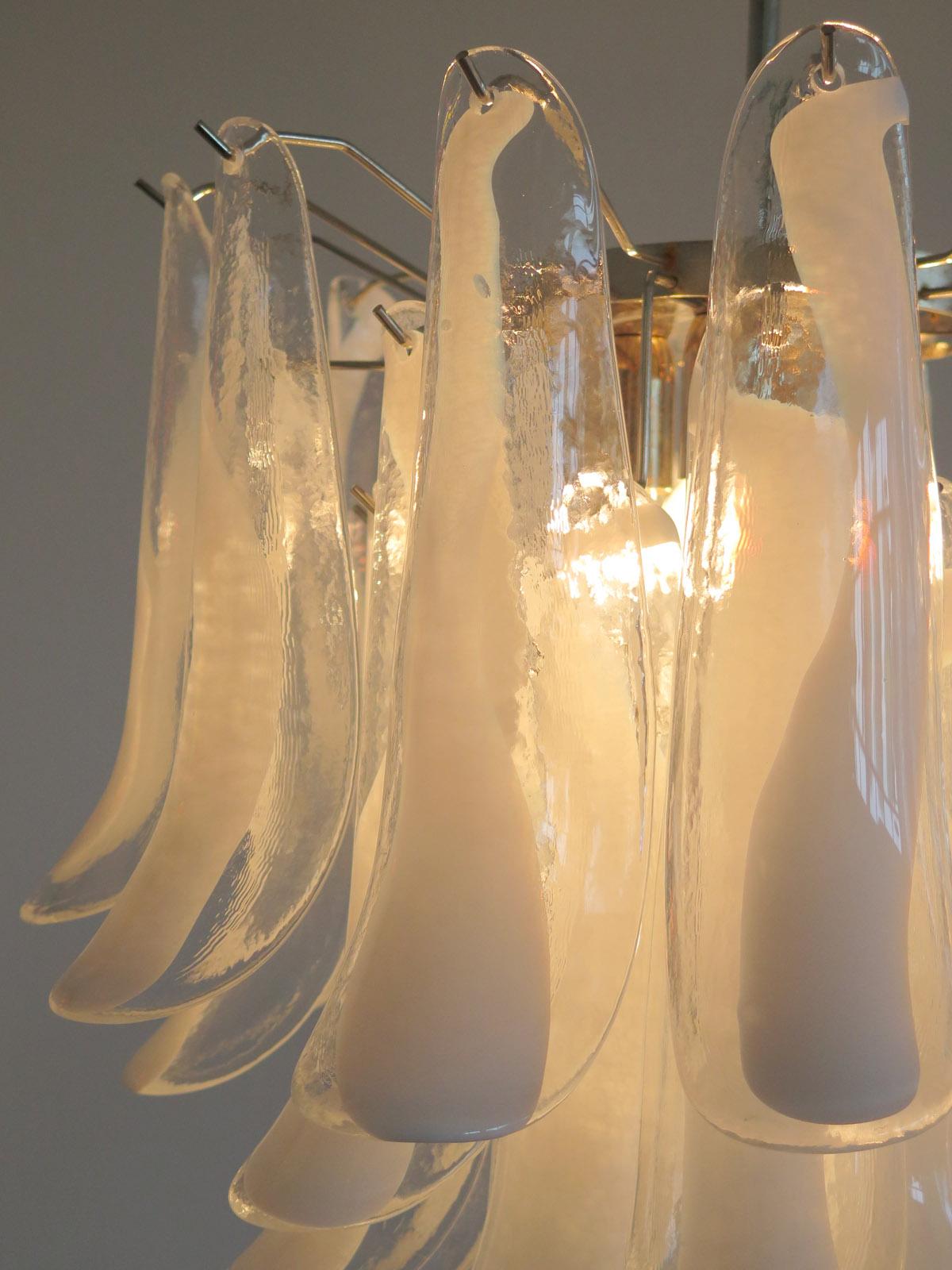 Huge Italian vintage Murano chandelier made by 41 glass petals (transparent and white “lattimo”) in a chrome frame.
Period: 1960s-1970s
Dimensions: 46 inches (117 cm) height with chain, 25.60 inches (65 cm) height without chain; 22,85 inches (58
